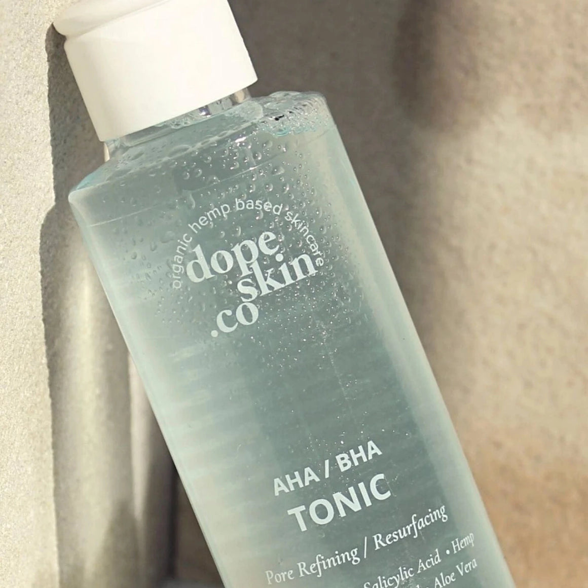 Bottle of Dope Skin Co. AHA/BHA Tonic on a neutral background