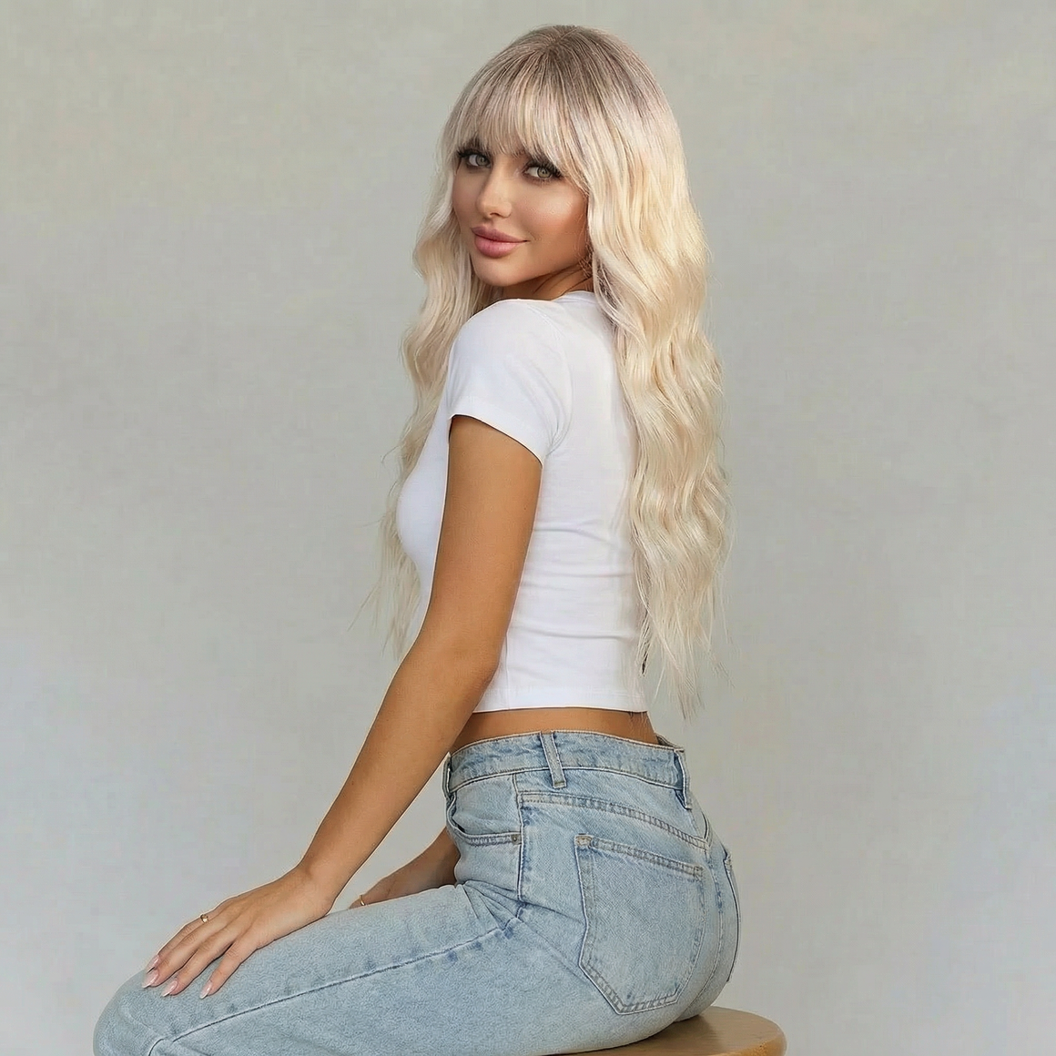Blaire Ash Blonde Beach Wave Synthetic Wig with Bangs styled on a model with long, tousled waves.