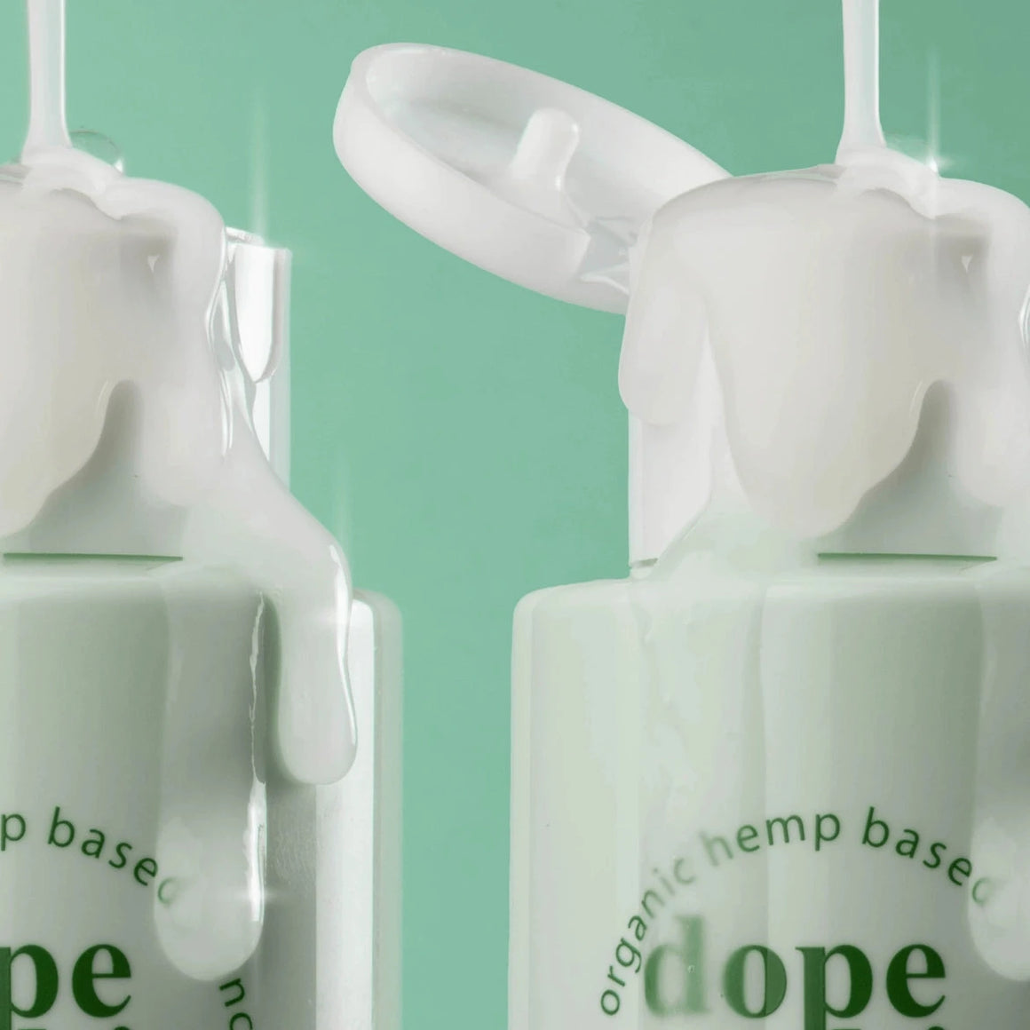 Two bottles of Dope Skin skincare product with droppers on a green background