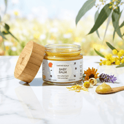Baby Balm with Lavender and Orange Oil 60ml  - Earthie Koala in a jar with bamboo lid, surrounded by flowers and natural elements.