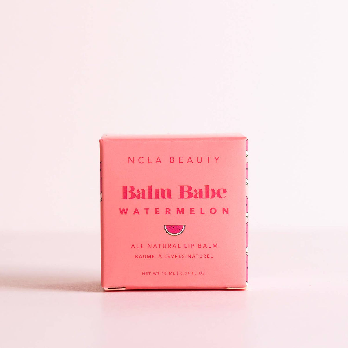 NCLA Beauty Balm Babe Watermelon lip balm packaging on a pink background