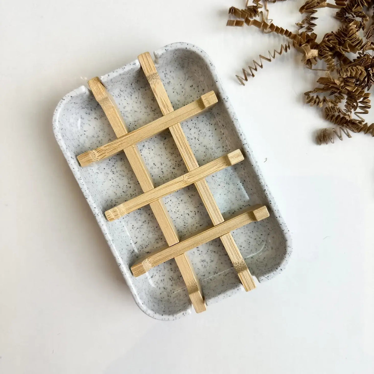 Ceramic tray with wooden grid on a light background