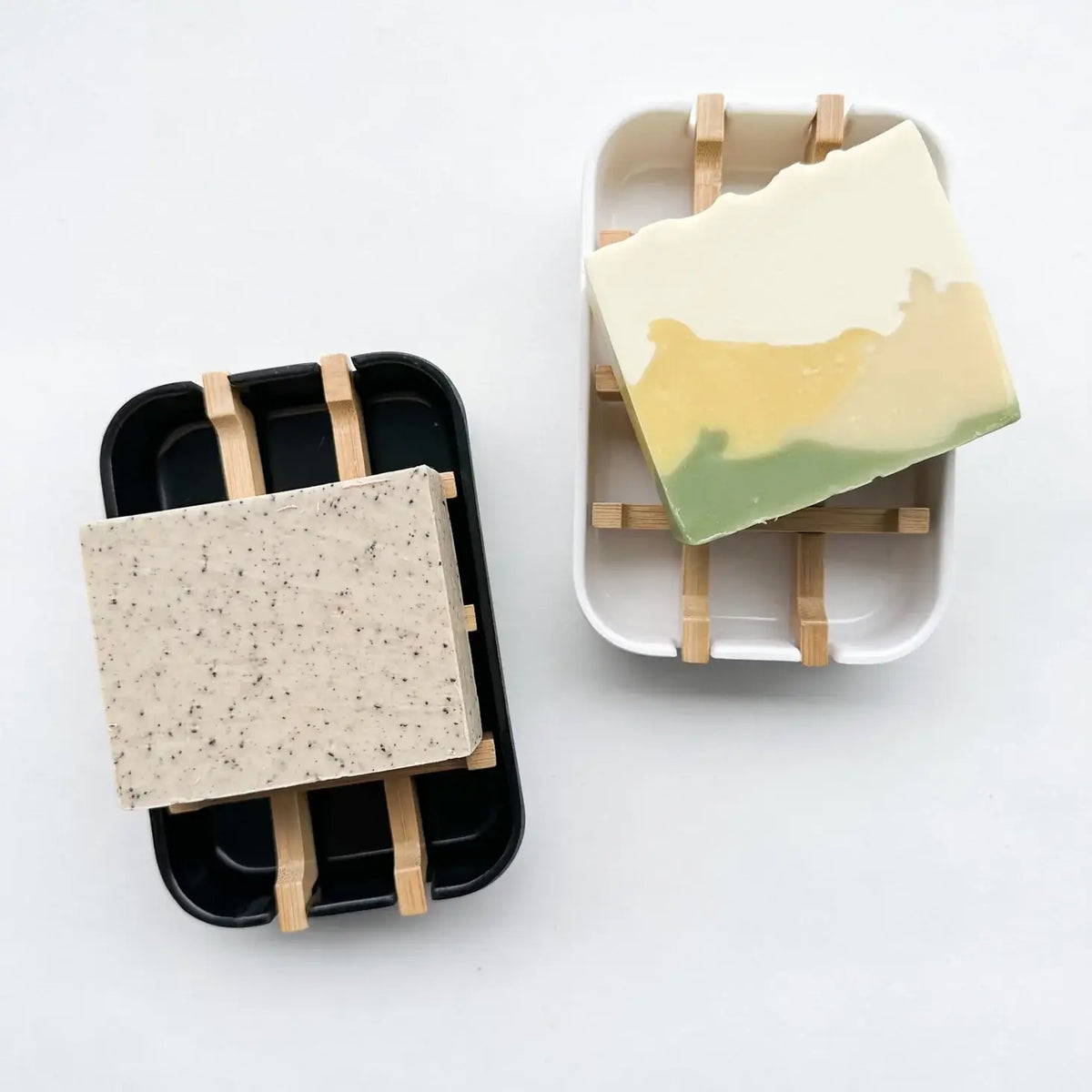 Two soap dishes with soap bars on a white background