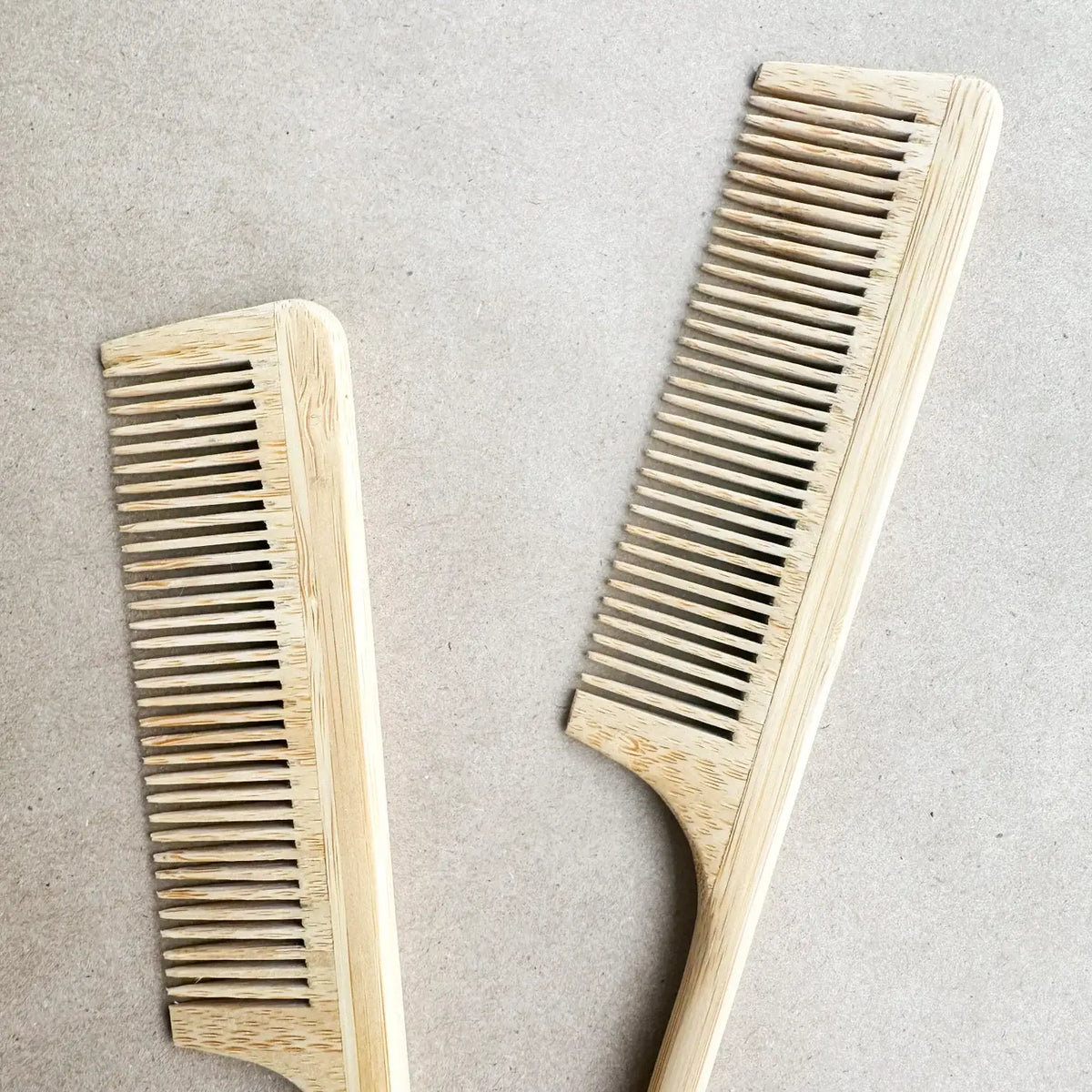 Two wooden combs on a light gray background
