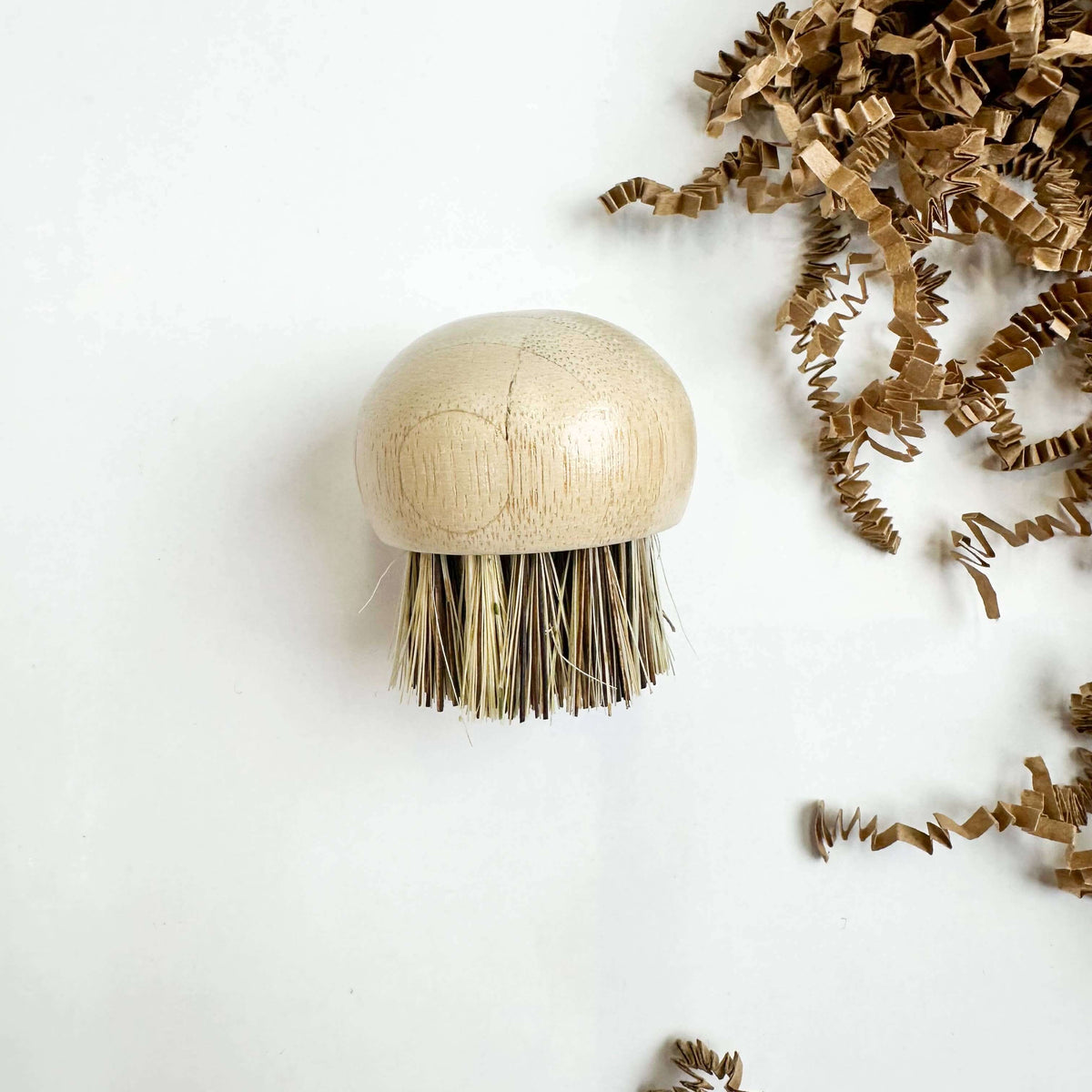 Beige scrub brush with bristles on a white background