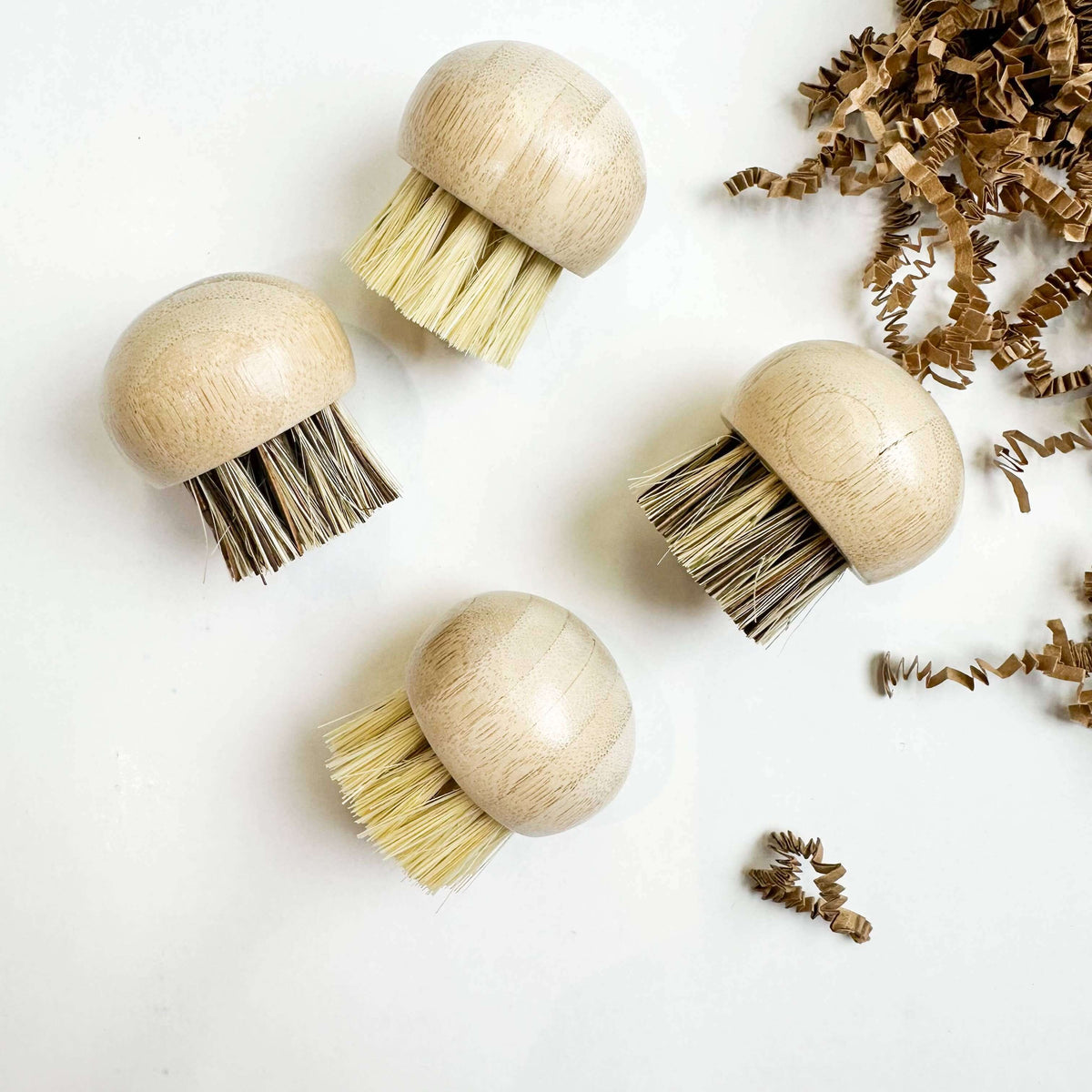 Four wooden brushes with bristle heads on a white background