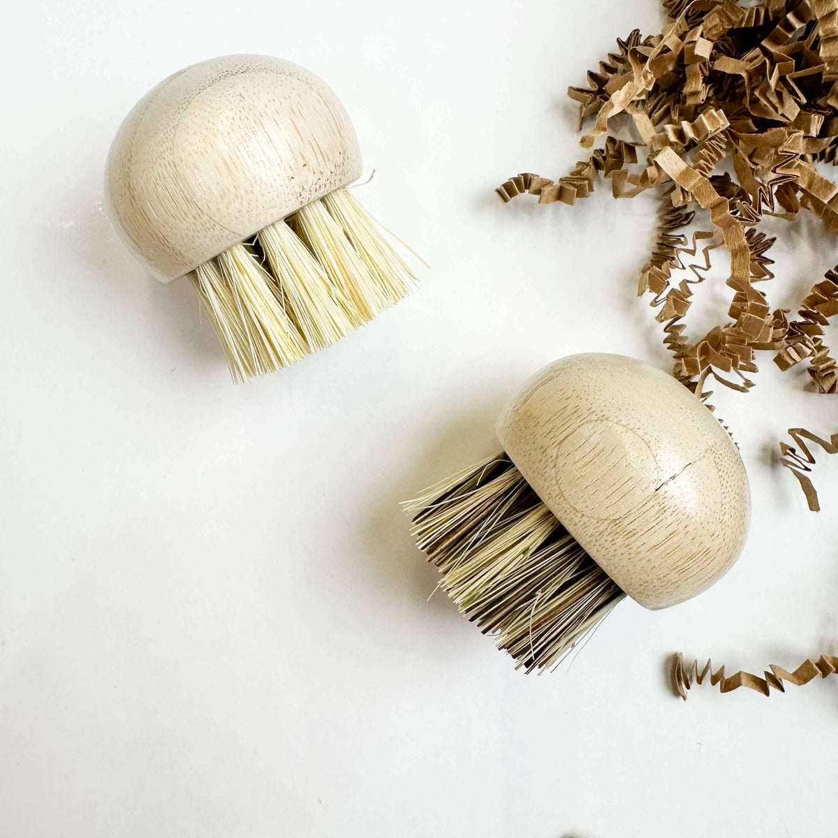 Two wooden brushes with bristle heads on a white background