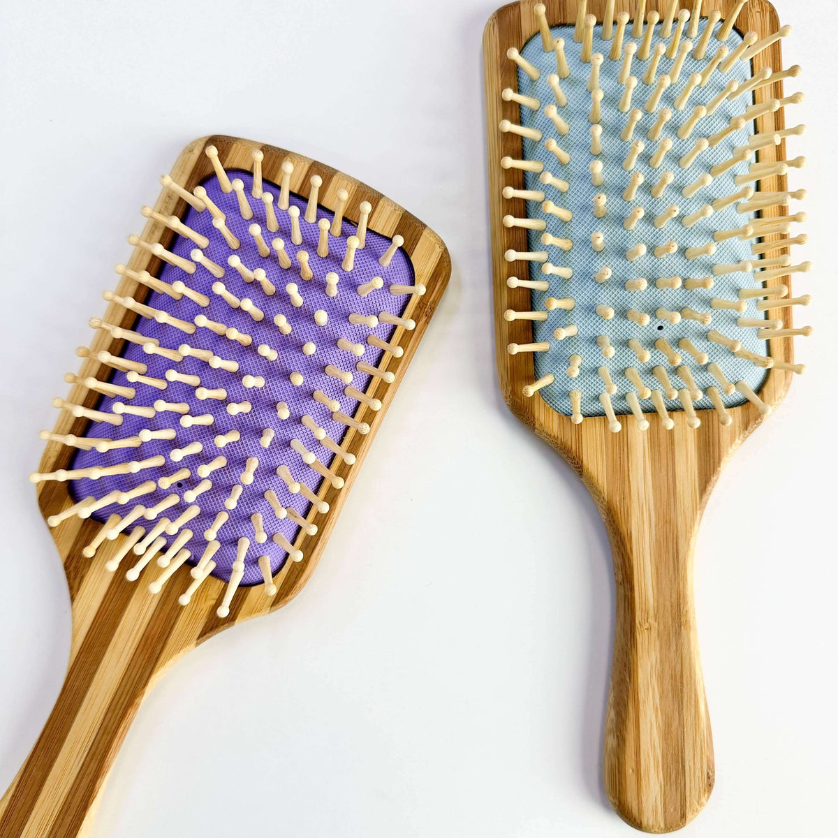 Bamboo Paddle Hair brush - Smile Boutiques, featuring purple and blue padded bristles for sustainable hair care.