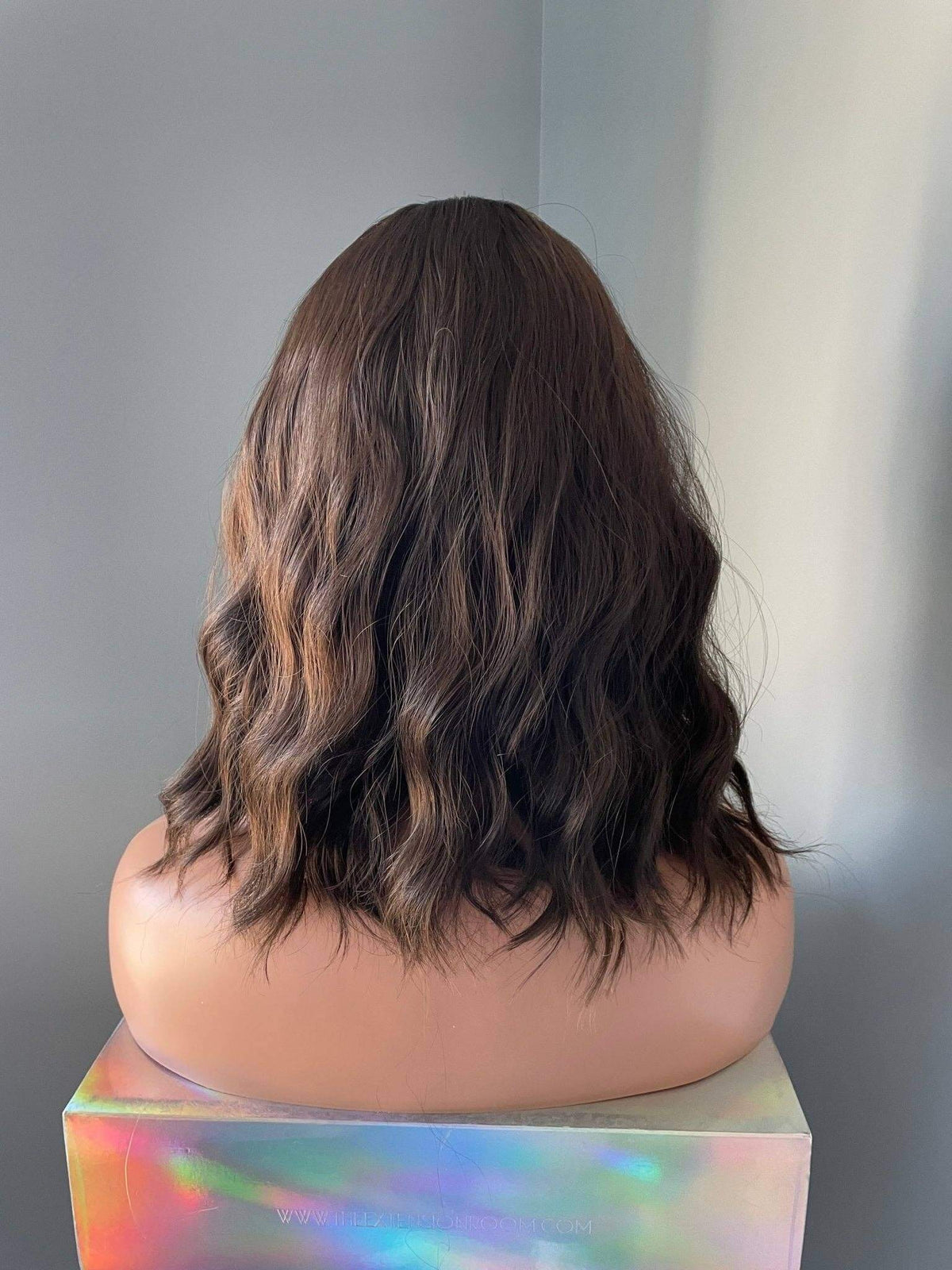 Back view of the Bianca Short Dark Brown Wig with Bangs showcasing soft body waves and natural movement.