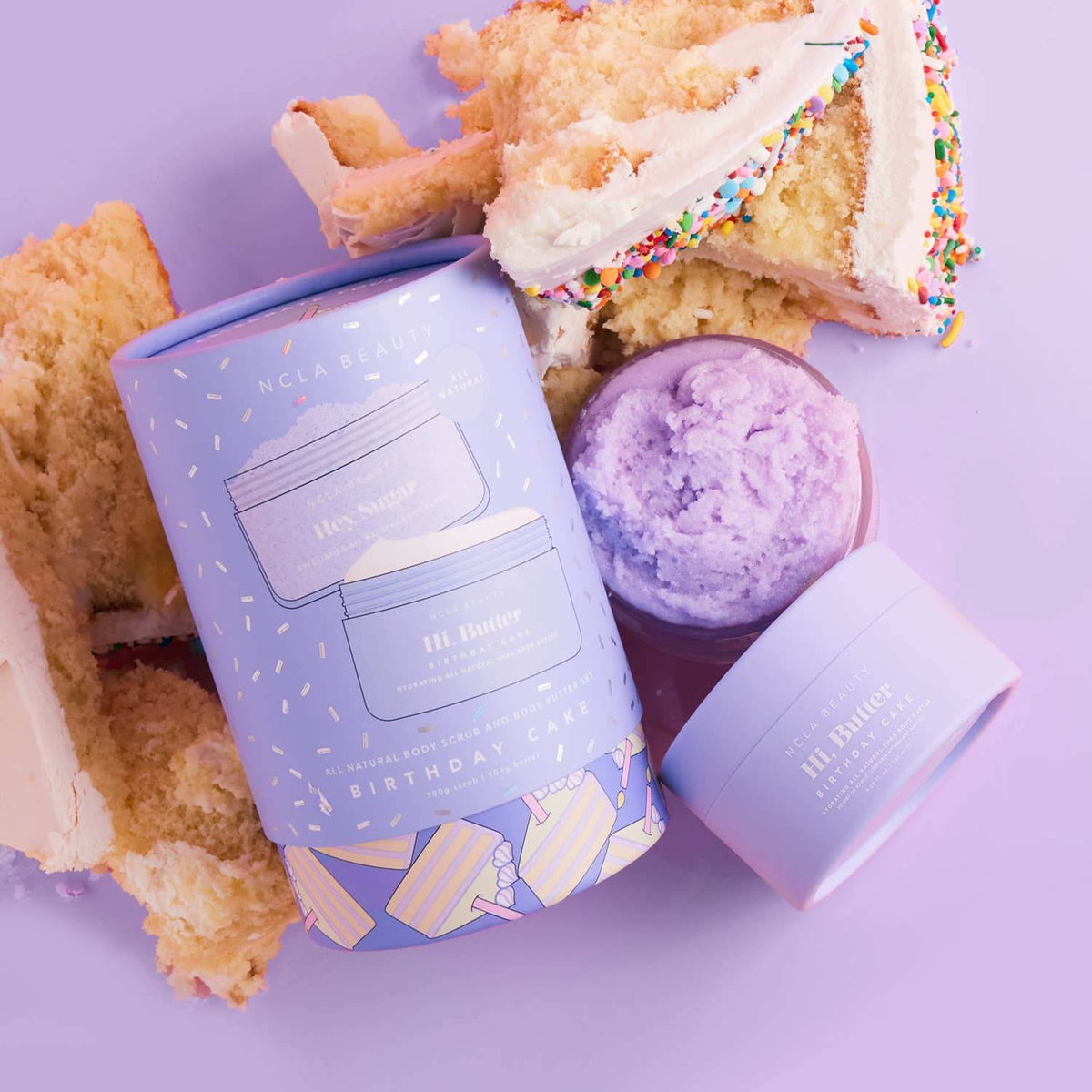 Purple bath bomb and packaging with cake and cookies on a purple background