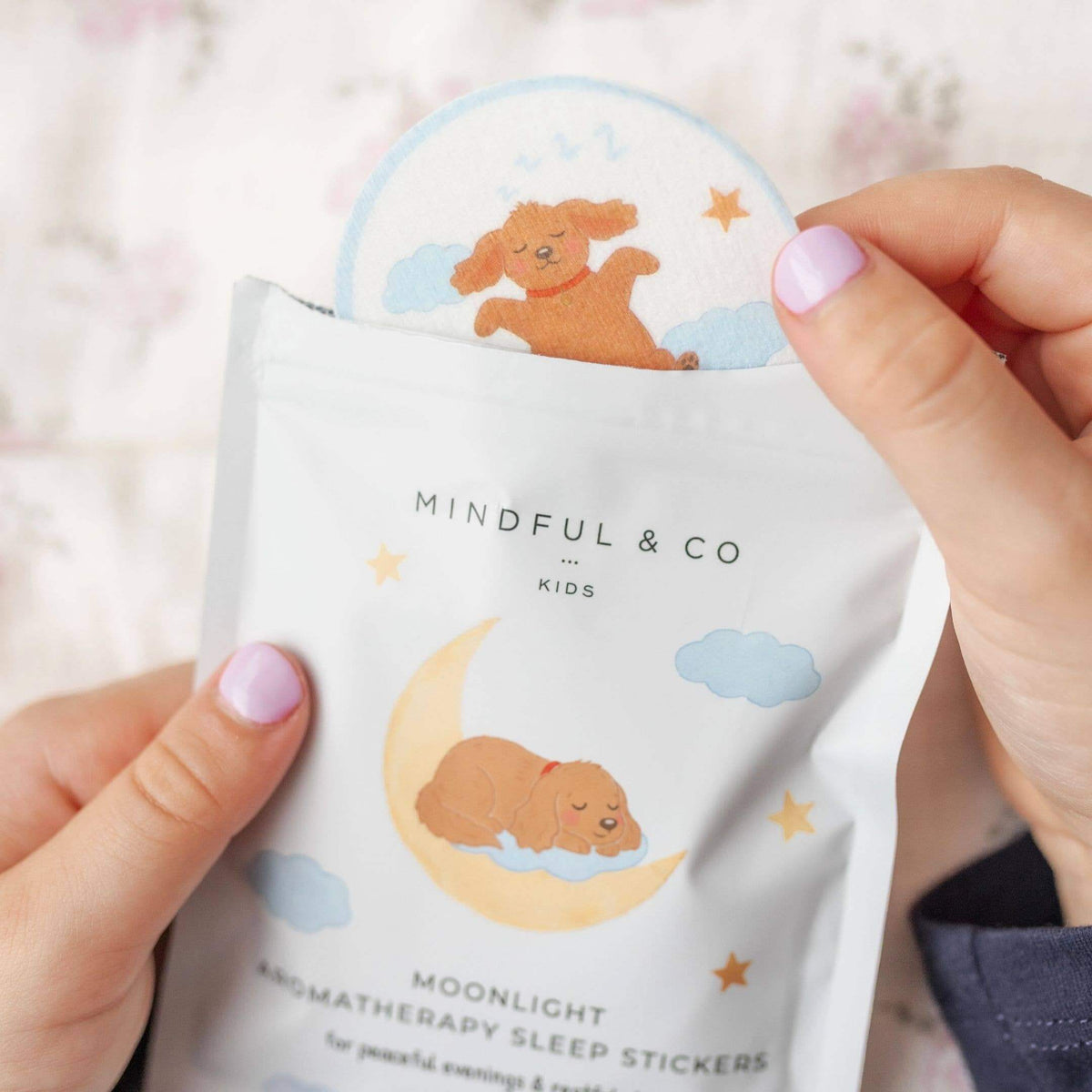 Hand holding a package of Mindful & Co Kids Moonlight Bodyatherapy Sleep Stickers with bear illustrations.