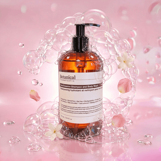 Bottle of Botanical Therapeutics shampoo and body wash with bubbles and flowers on a pink background
