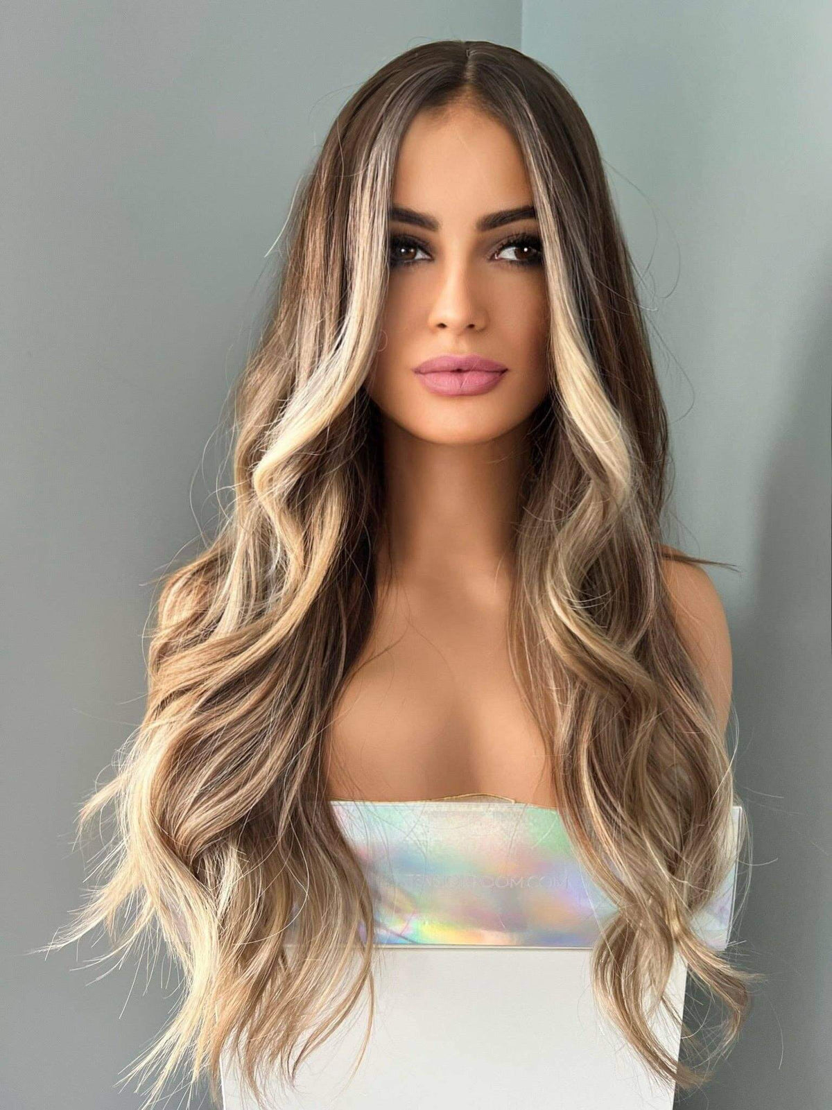 Brianna Long Brown Wig With Highlights styled on a model, featuring soft brown waves and blonde highlights.