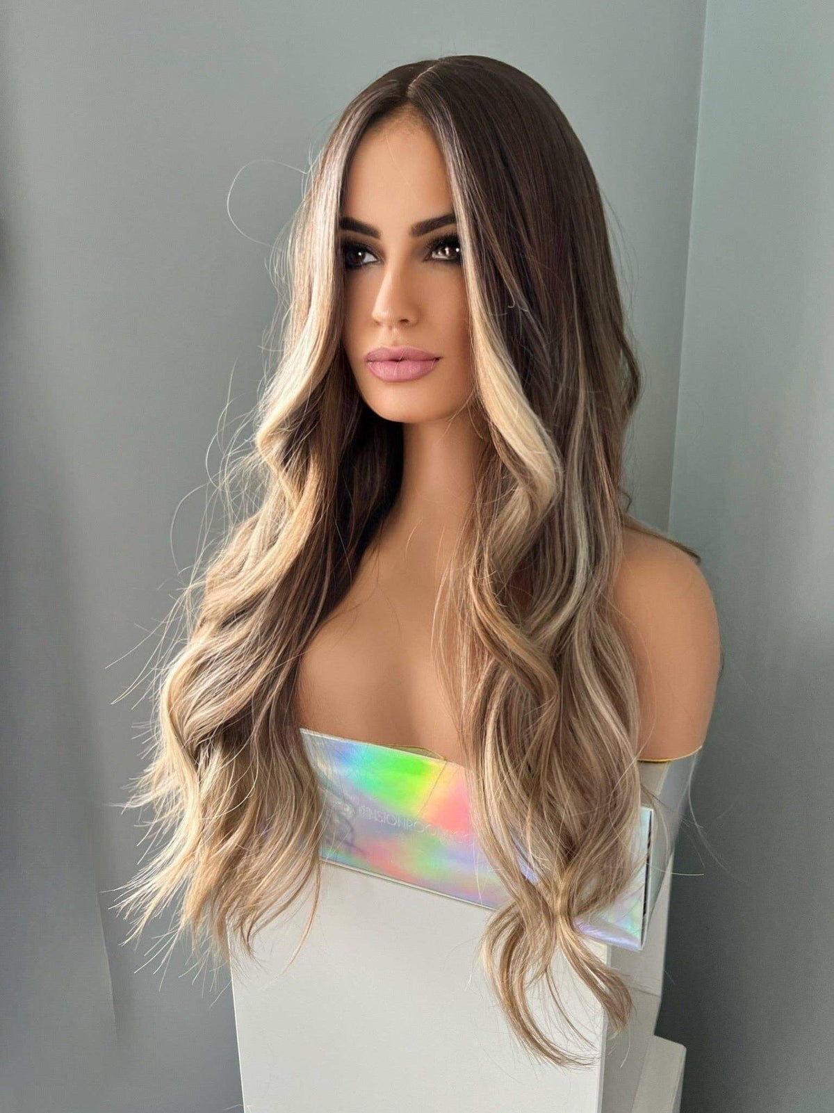 Brianna Long Brown Wig With Highlights displayed on a mannequin showcasing soft waves and blonde highlights.