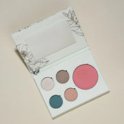 Makeup palette with five different colored blushes on a beige background