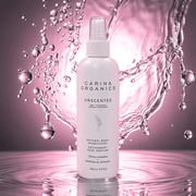 Carina Organics unscented deodorant bottle with water droplets on a pink background