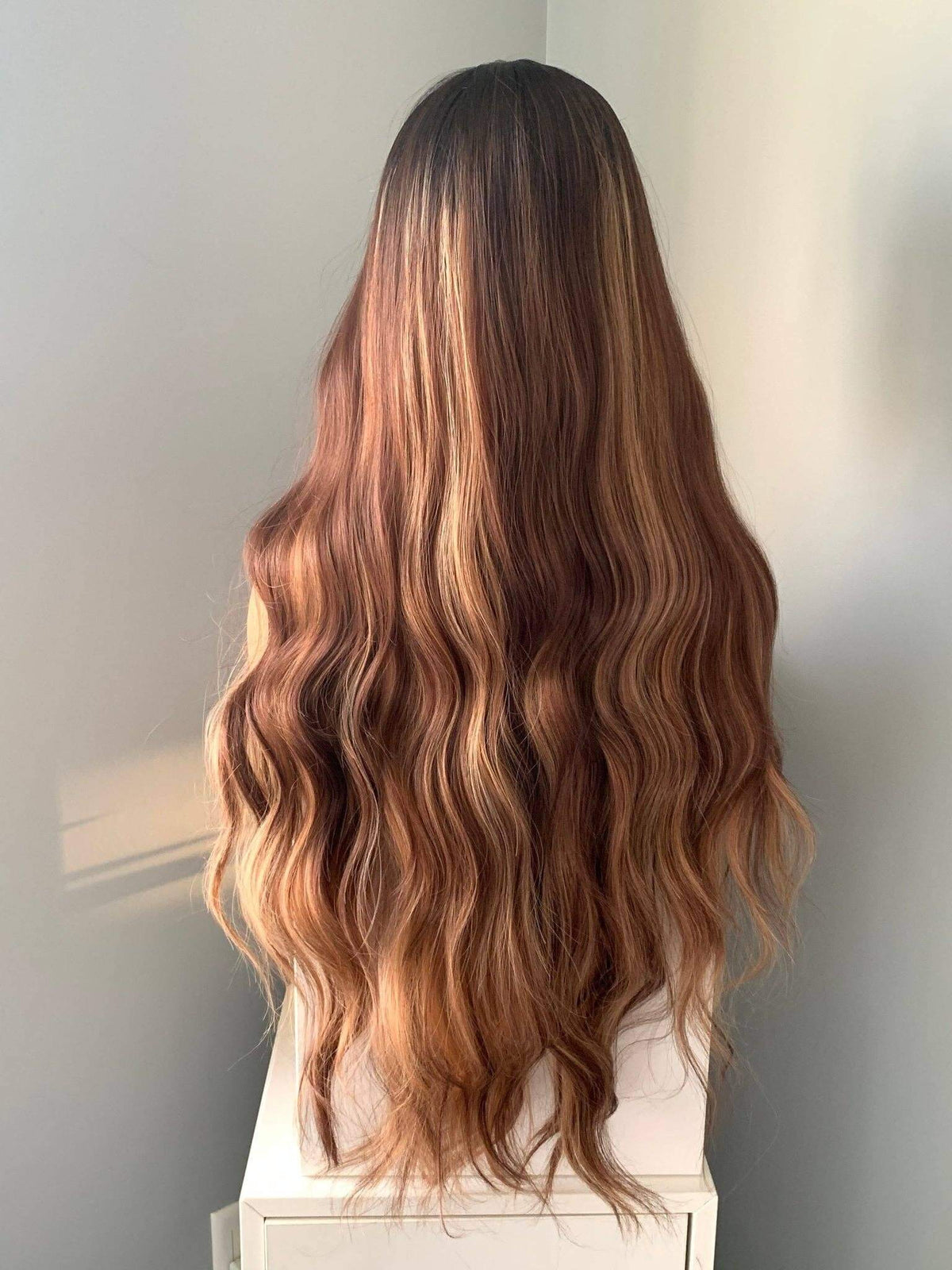 Long, wavy hair with a gradient color on a neutral background