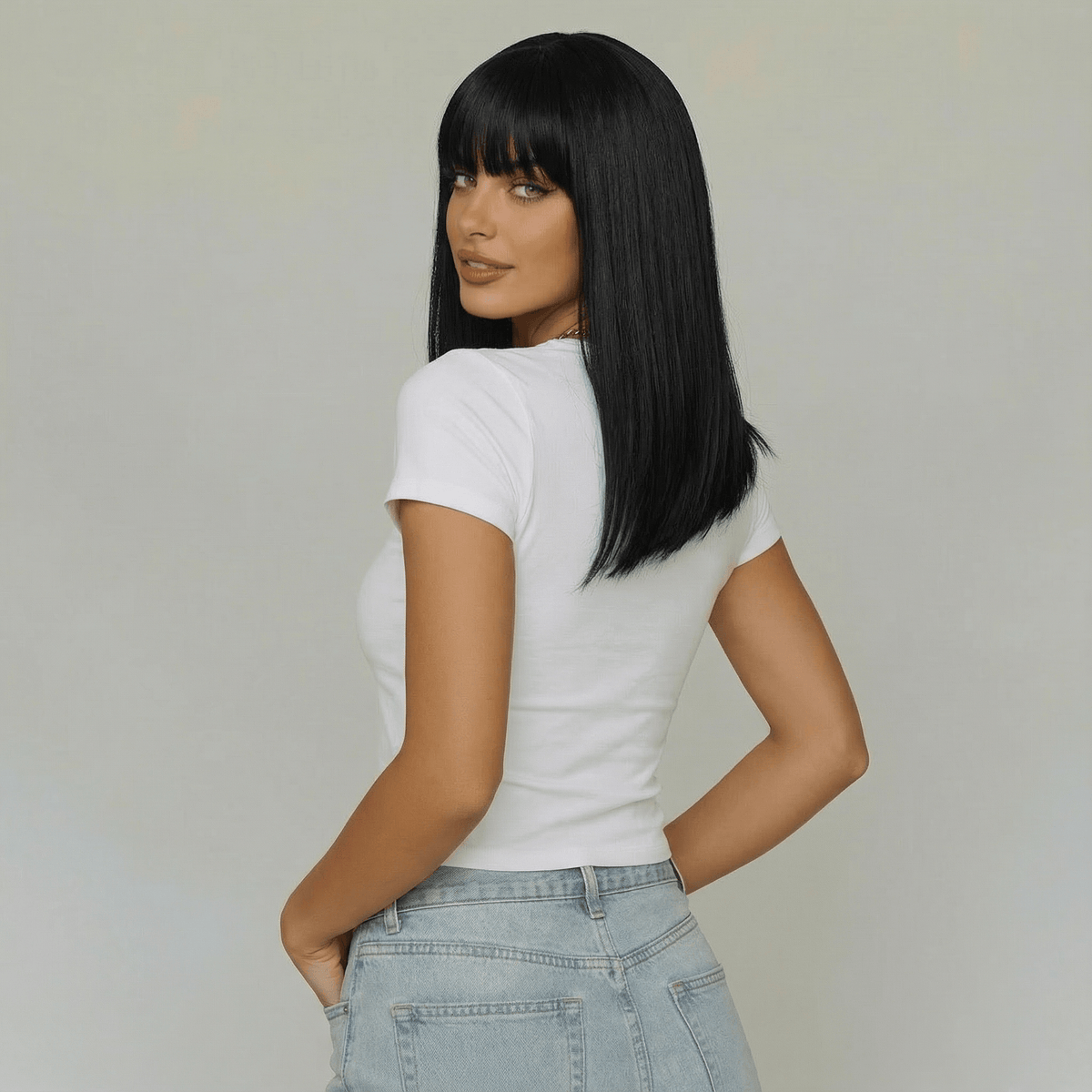 Cecil short black wig with bangs worn by a model showing a sleek bob haircut from the back.