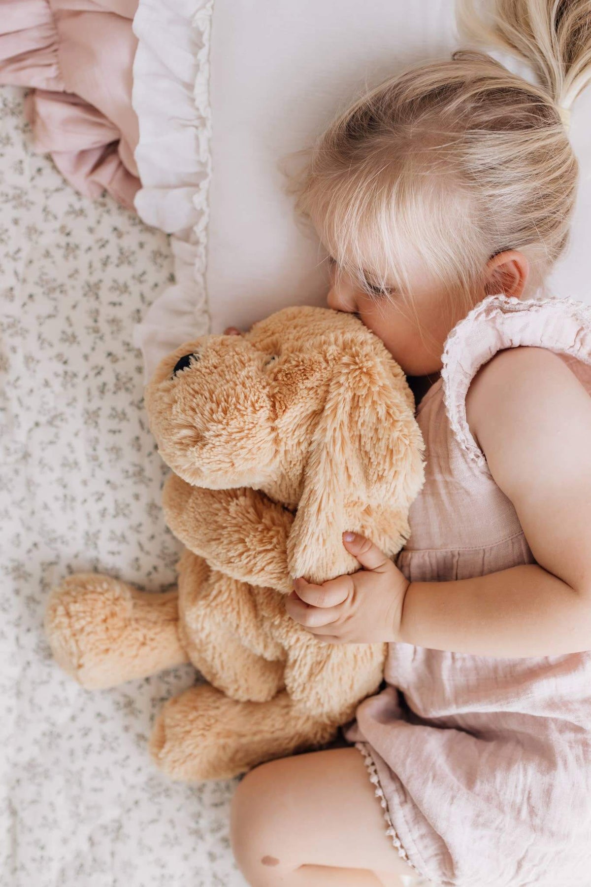 Child cuddling Charlie The Weighted Puppy Dog Teddy on a bed, enjoying comfort and emotional support.