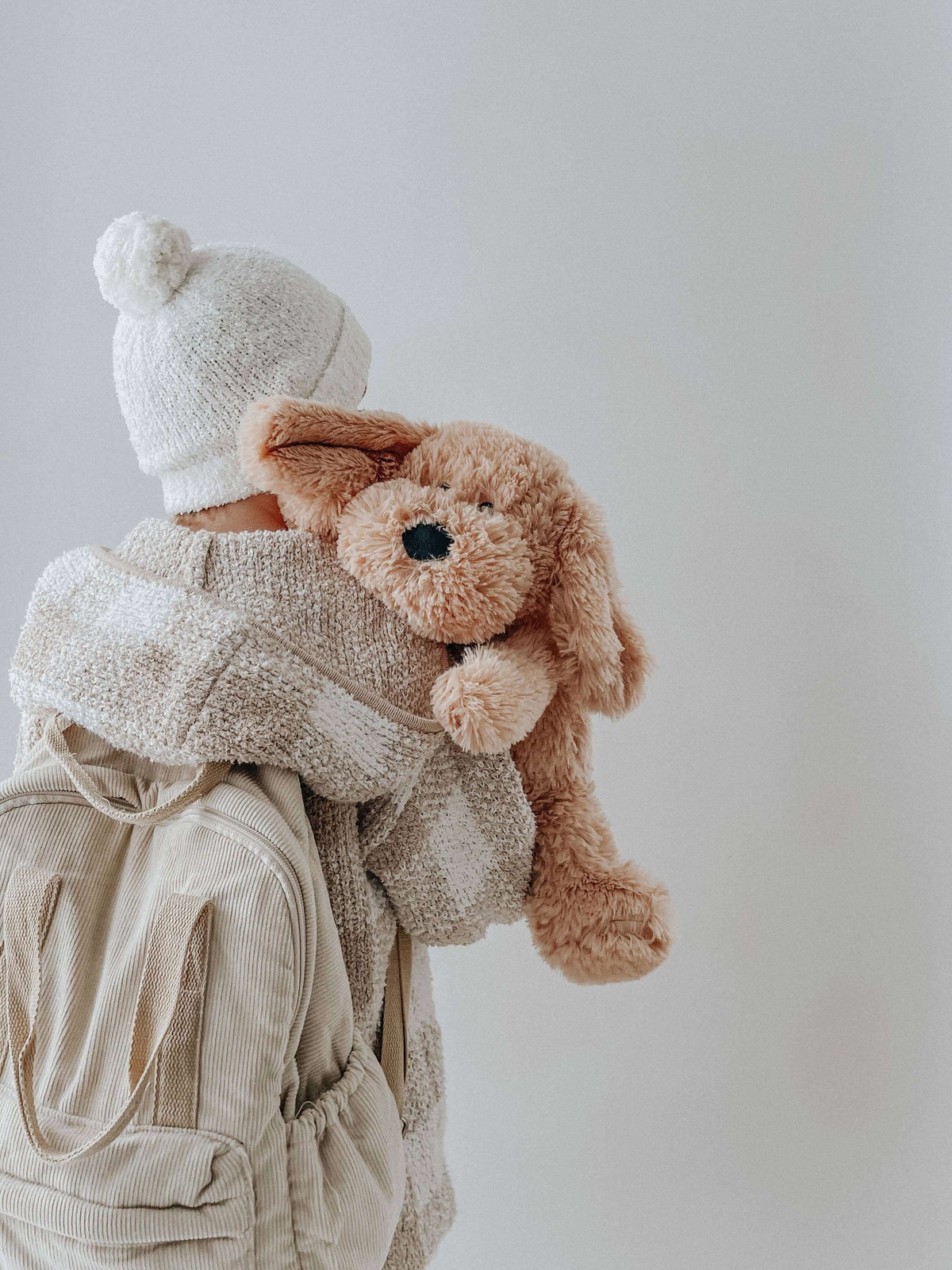 Child hugging Charlie The Weighted Puppy Dog Teddy, a cozy plush toy designed for comfort and emotional support.