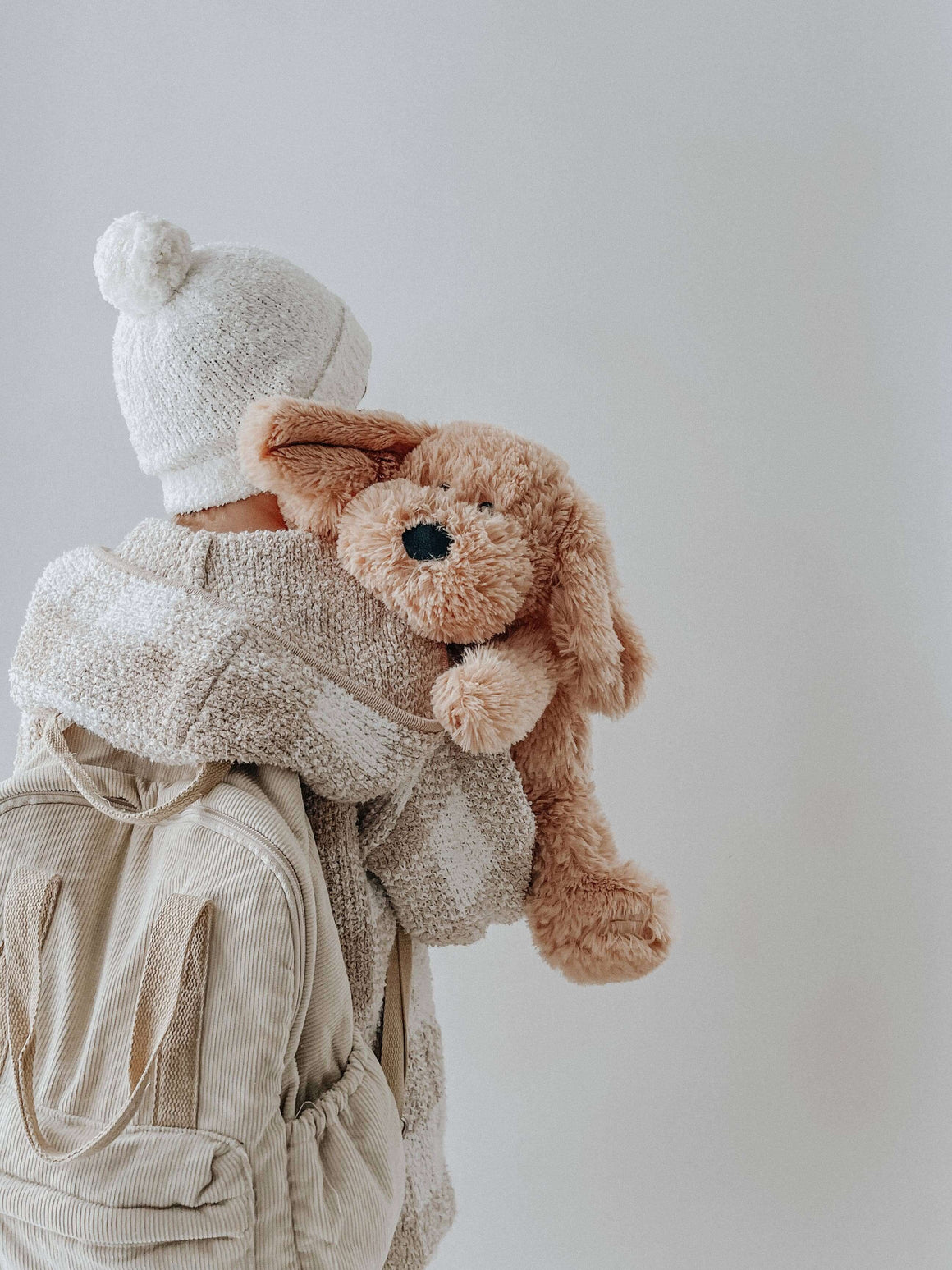 Child hugging Charlie The Weighted Puppy Dog Teddy, a cozy plush toy designed for comfort and emotional support.