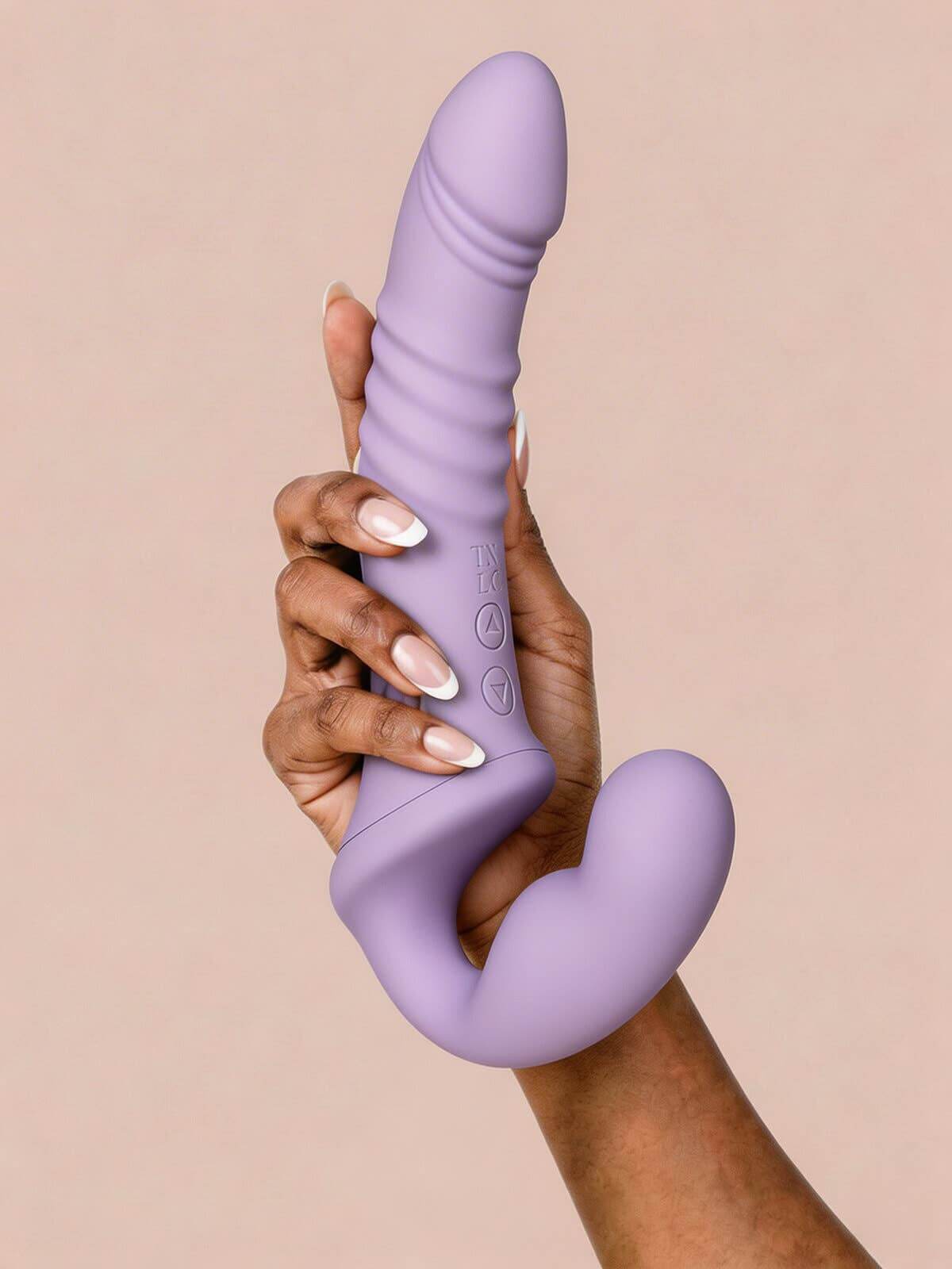 Hand holding the Clary Luxe Thrusting Strapless Strap-on, a strapless thrusting strap-on for couples in pastel violet.