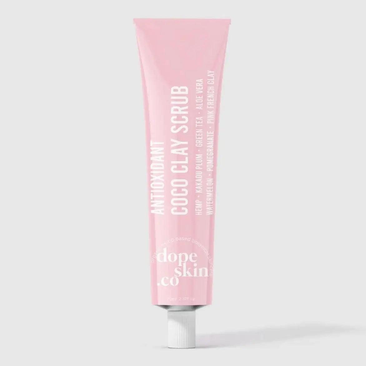 Pink tube of COCO CLAY SCRUB by dope Skin co on a light gray background
