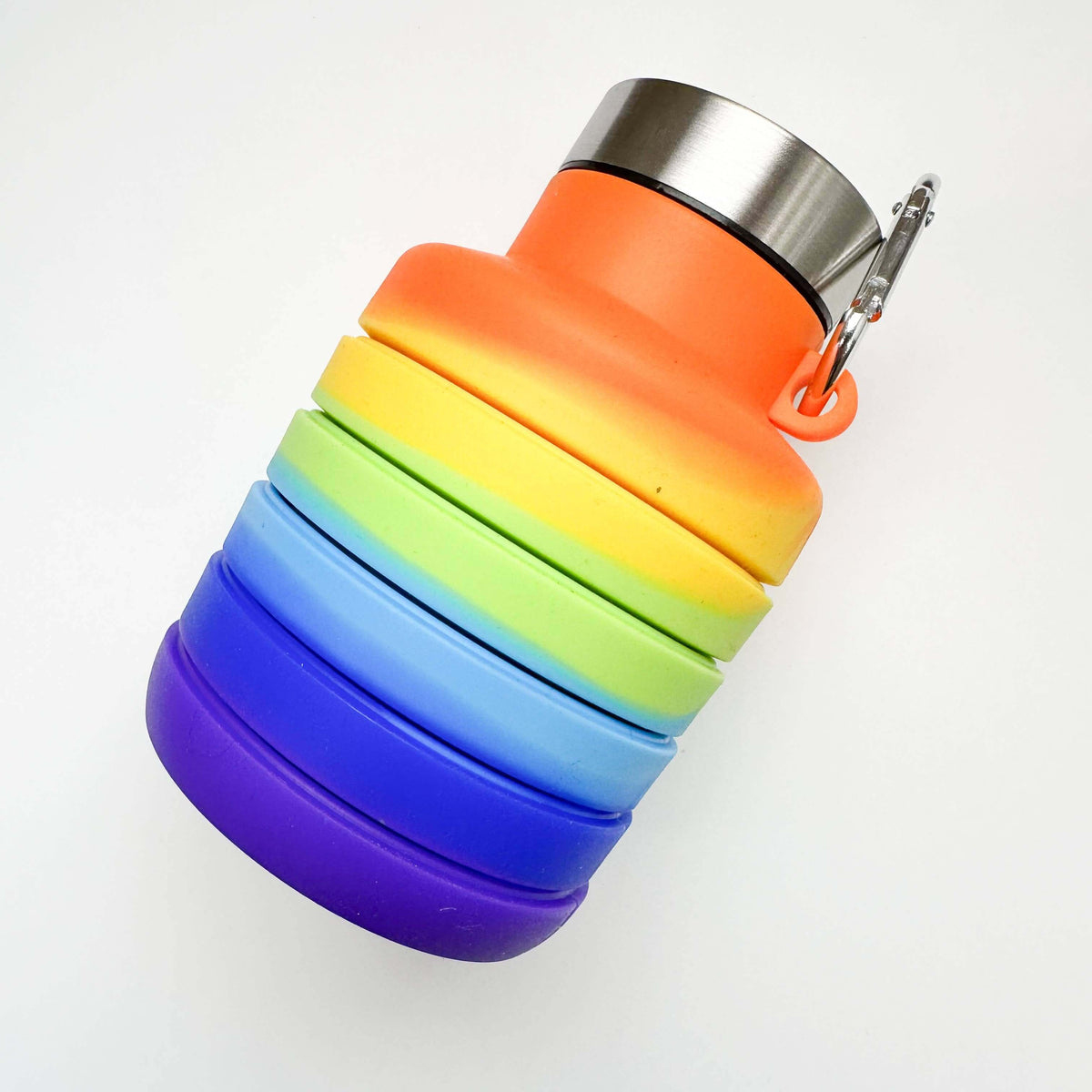Collapsible rainbow-colored water bottle with a silver cap on a white background