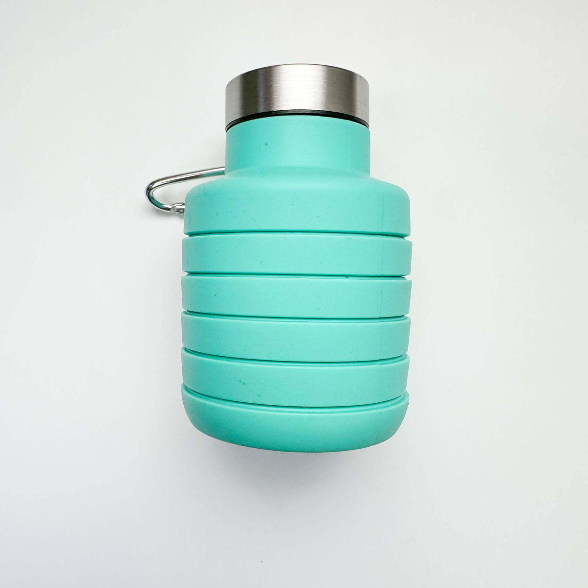 Collapsible turquoise water bottle with silver cap on a white background