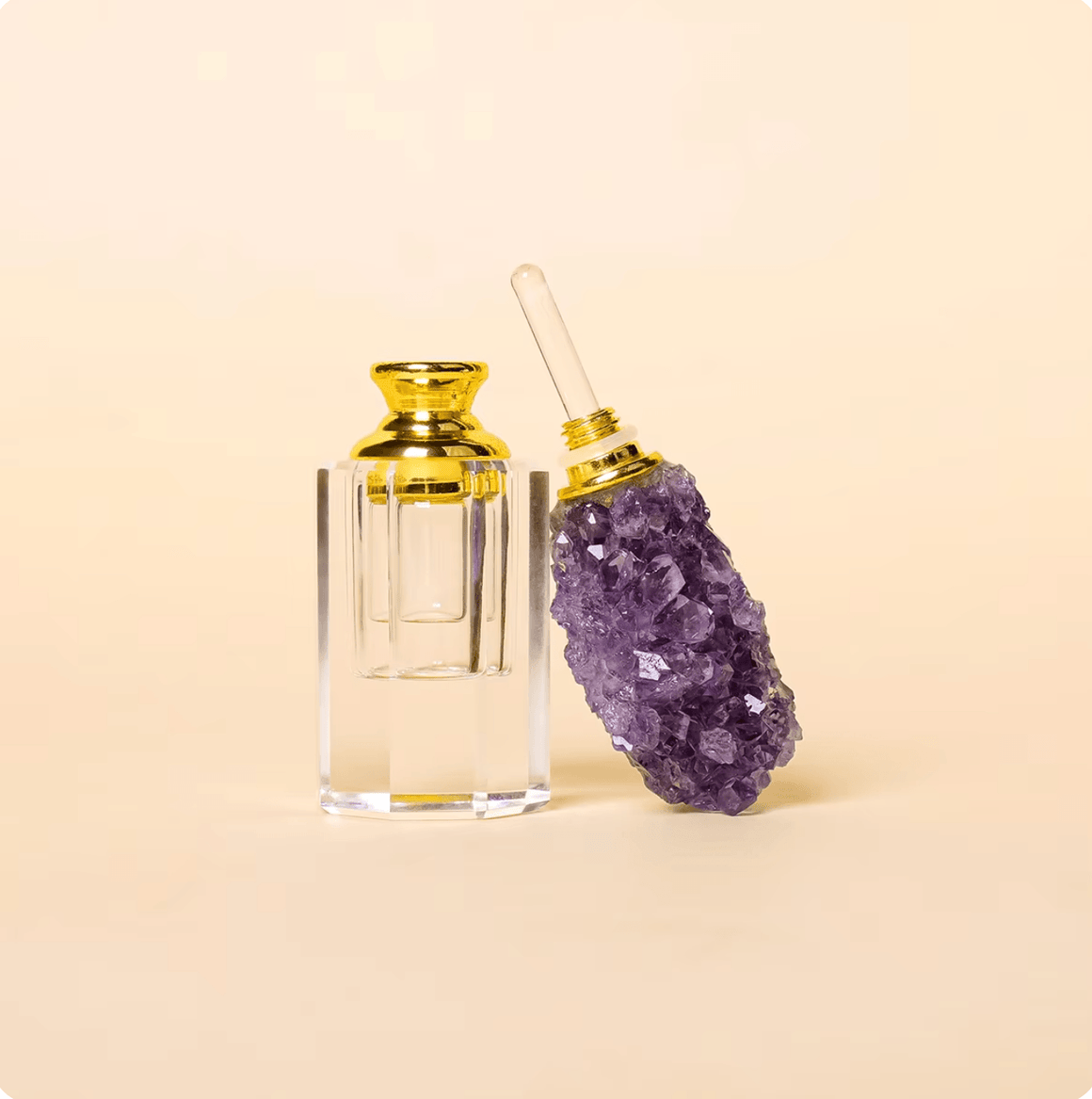 Crystal Gem Stone Essential Oil Bottle with purple gemstone and gold accents on a light background.