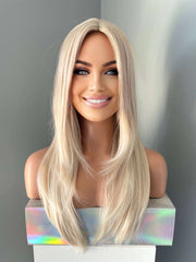 Blonde wig on a mannequin head against a gray background