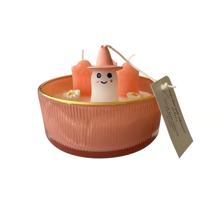 Candle with a small figurine inside on a white background