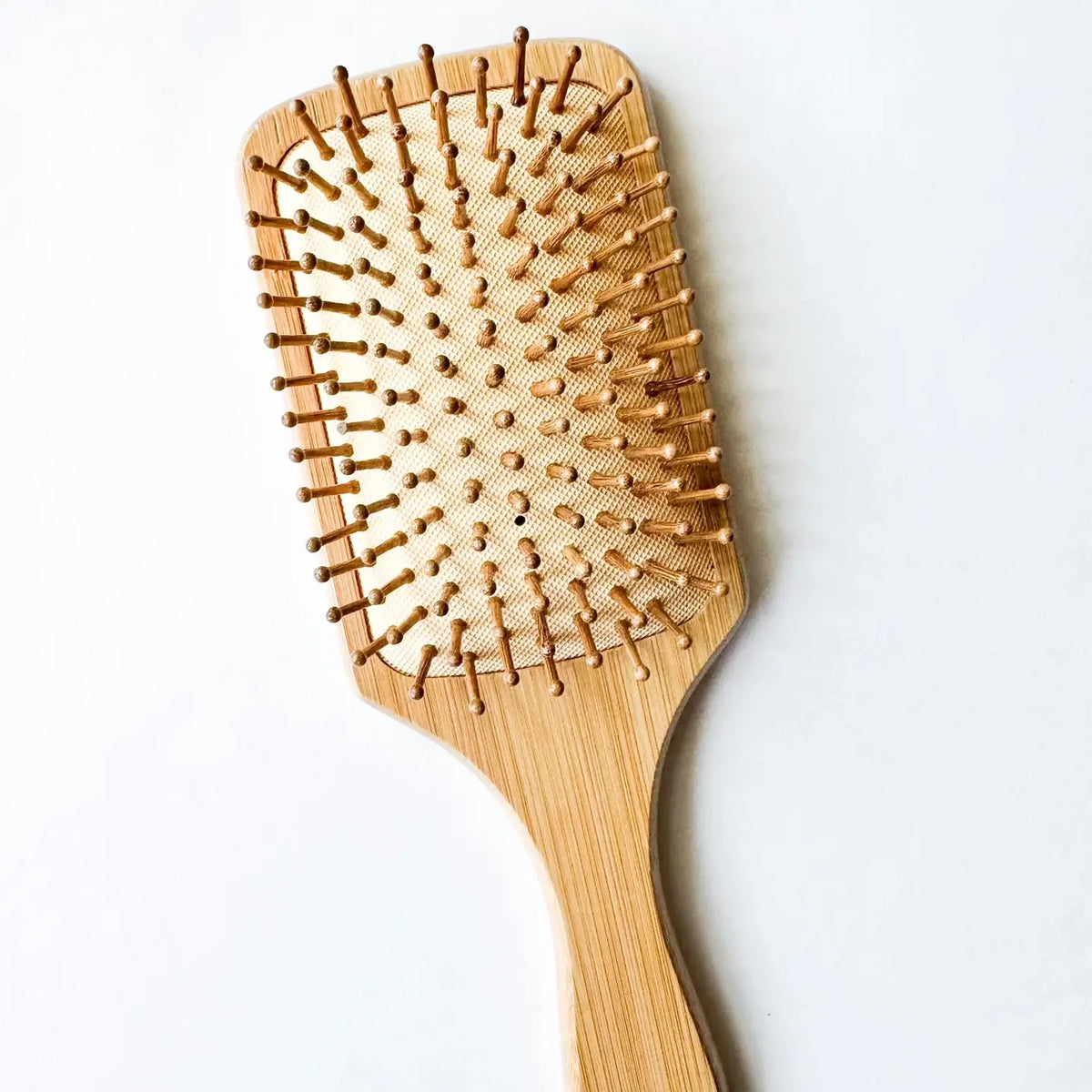 Wooden paddle hairbrush on a white background