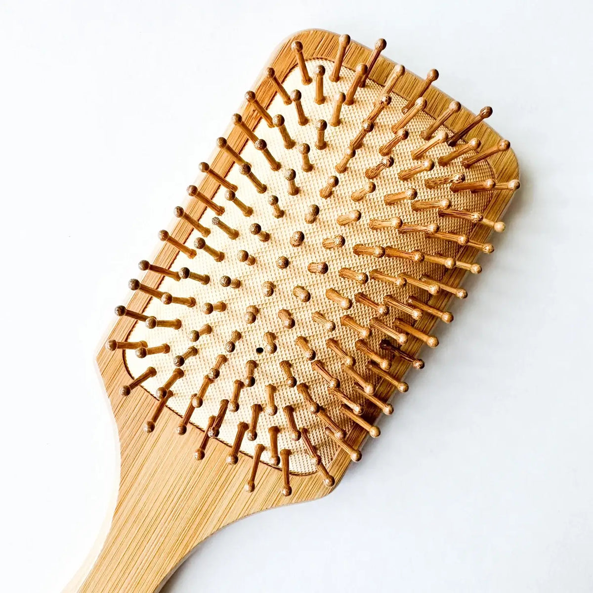 Wooden hairbrush with a textured surface on a white background
