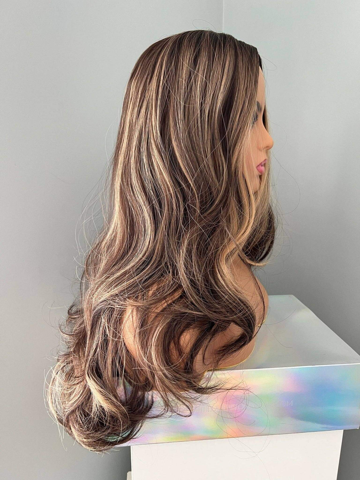 Side view of Devon Long Brown Curled Wig With Highlights showcasing cascading curls and golden caramel highlights.
