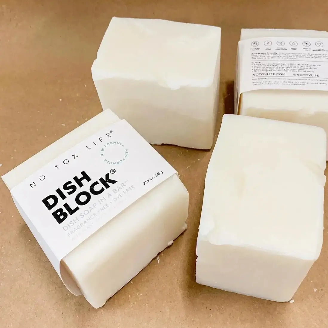 Dish blocks with 'No Tox Life' packaging on a brown surface