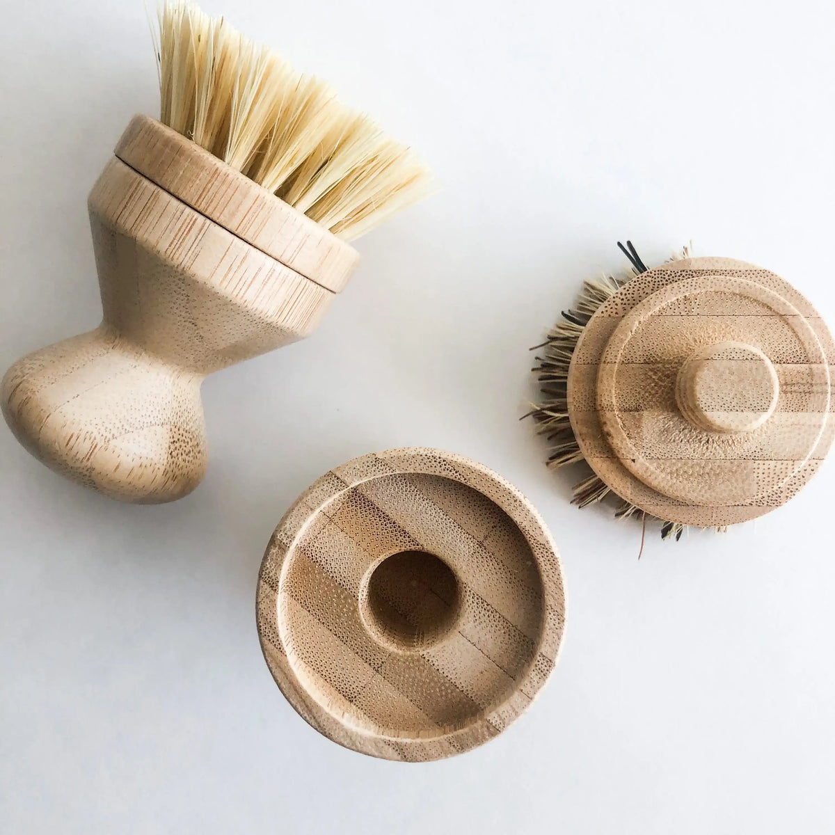 Three wooden cleaning brushes on a white background