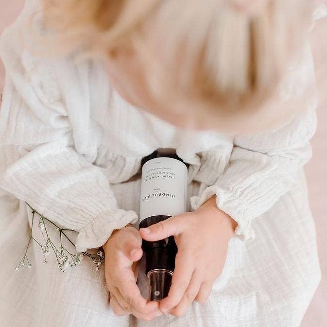 Person holding a bottle of aromatherapy spray sleep mist with a blurred background