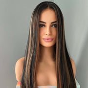 Woman with long, straight hair wearing a holographic top against a gray background