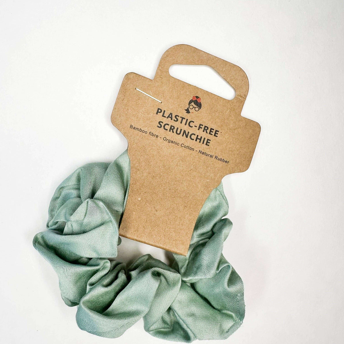 Green scrunchie on a cardboard holder with 'Plastic-Free Scrunchie' text on a white background