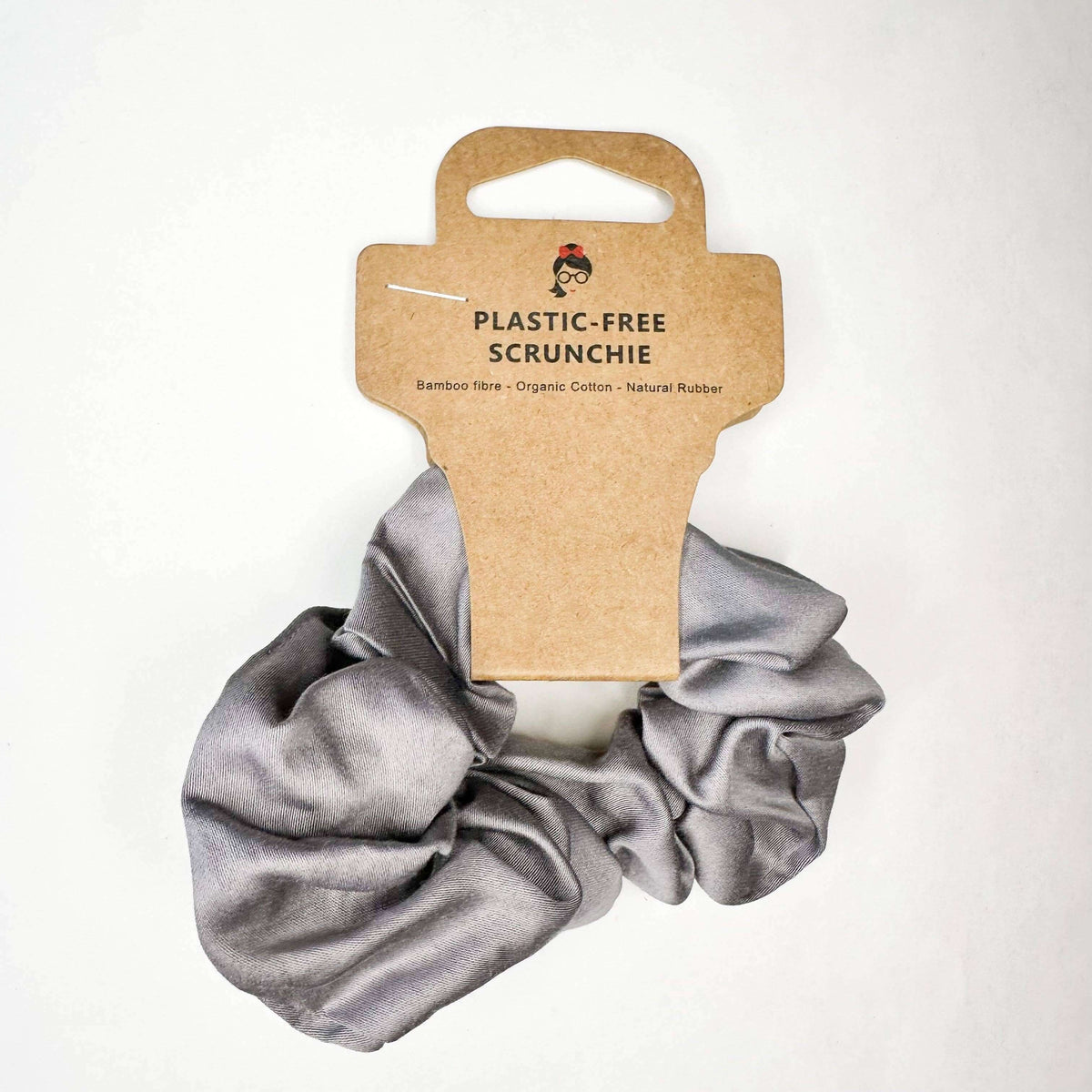 Gray scrunchie on a white background with a cardboard tag labeled 'Plastic-Free Scrunchie'.
