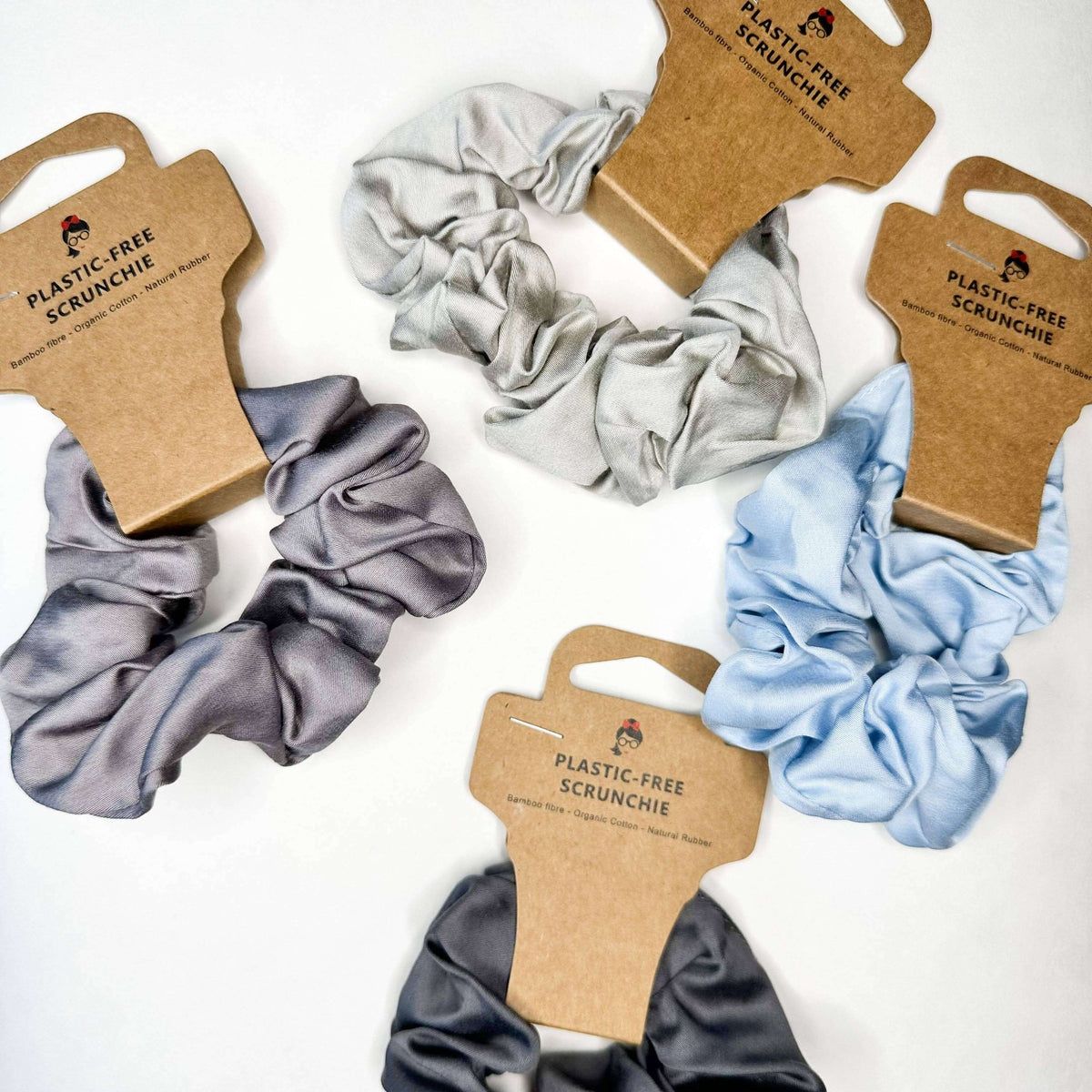 Set of plastic-free scrunchies with cardboard packaging on a white background