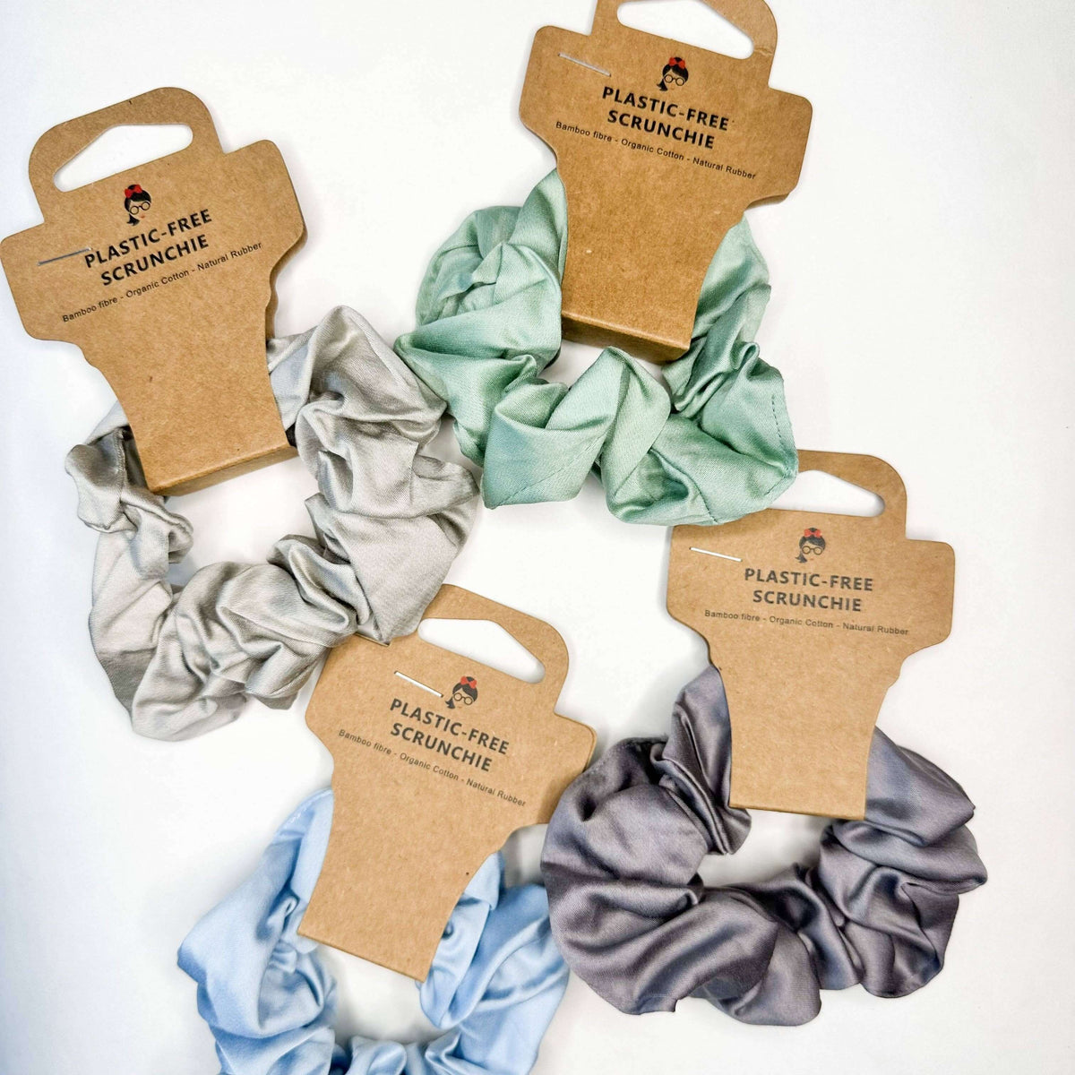 Set of plastic-free scrunchies on brown card packaging with visible brand name.