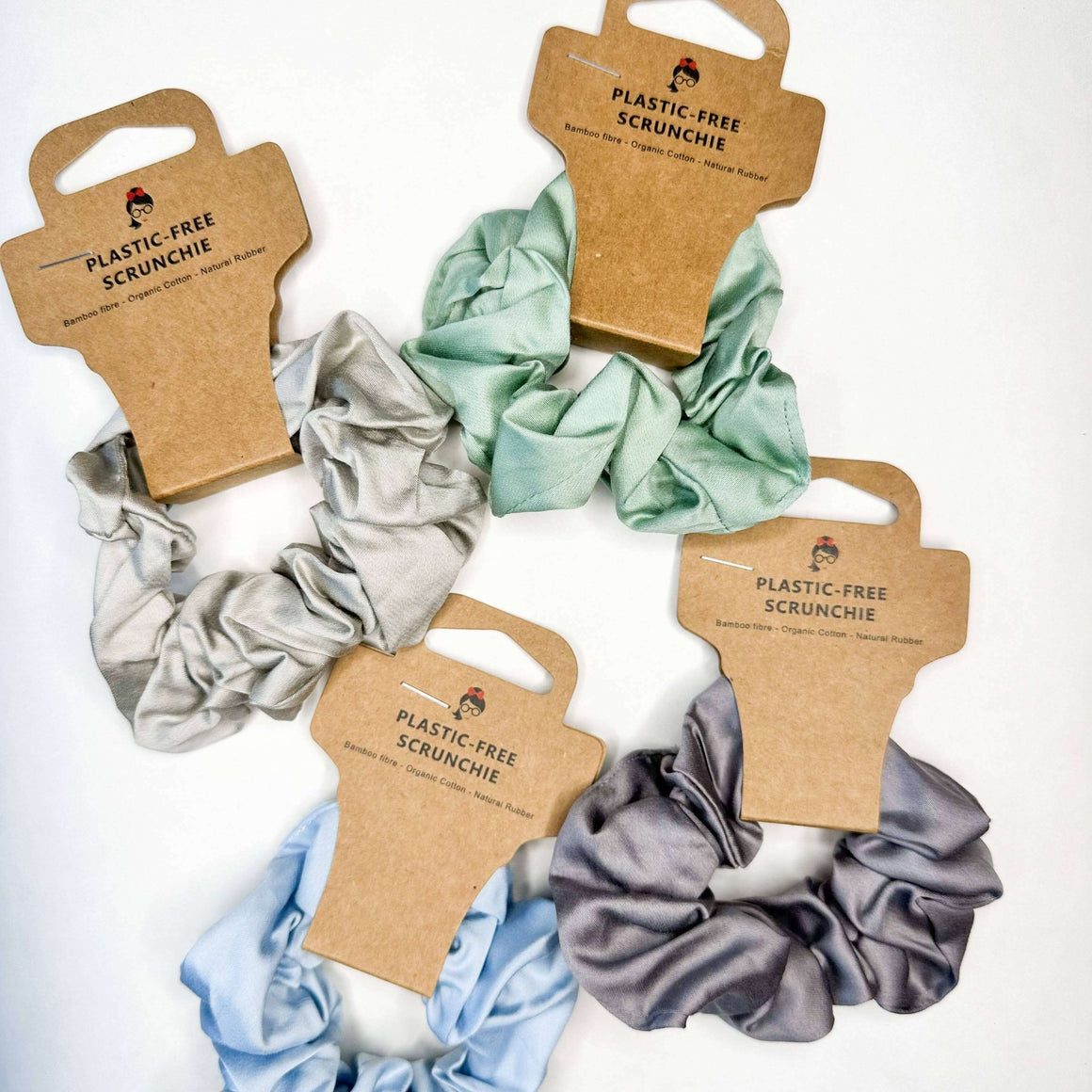 Set of plastic-free scrunchies on brown card packaging with visible brand name.