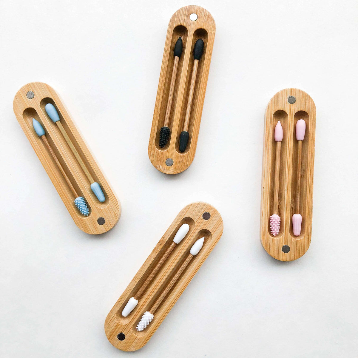 Set of four wooden toothbrush holders with toothbrushes on a white background
