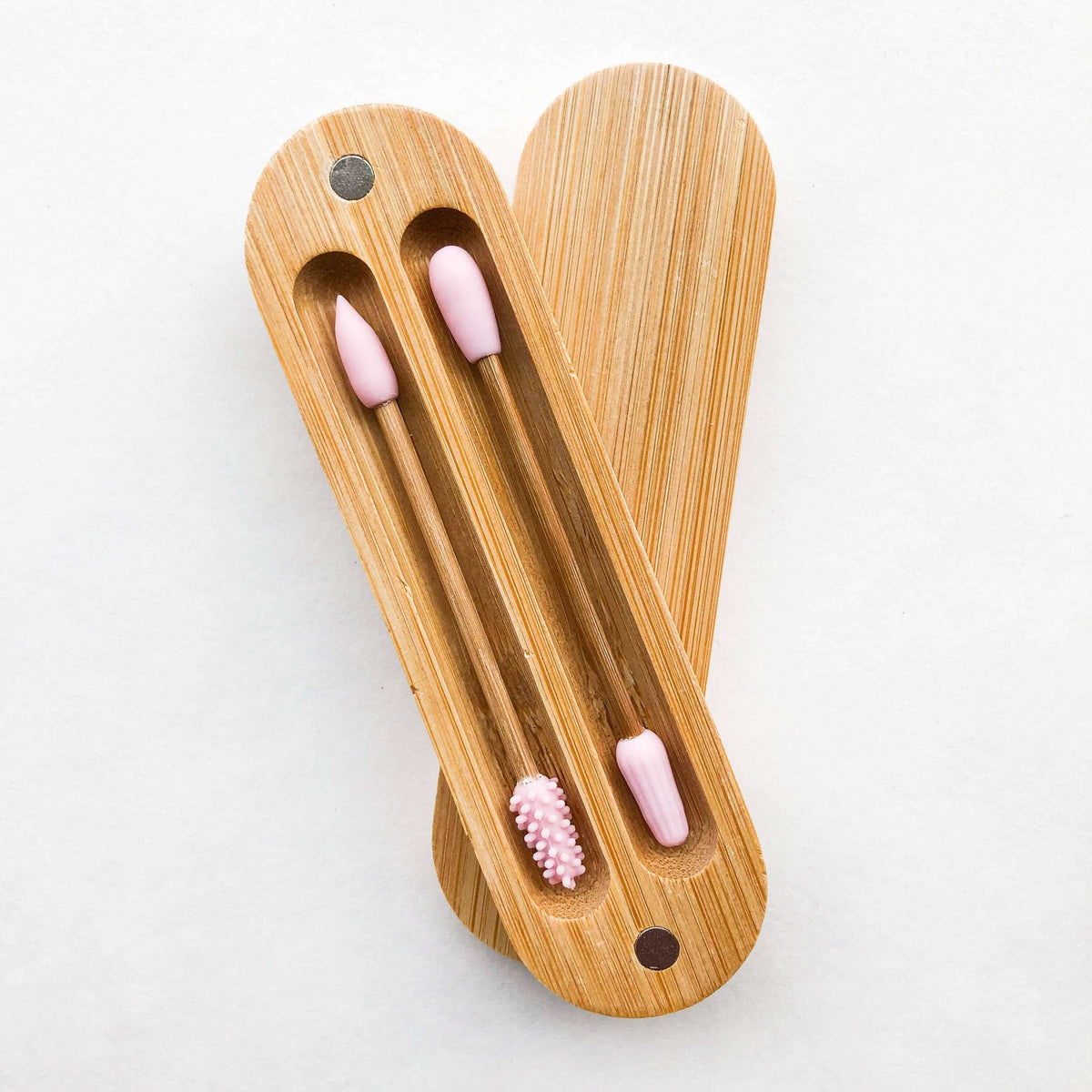 Wooden toothbrush holder with pink toothbrushes on a white background