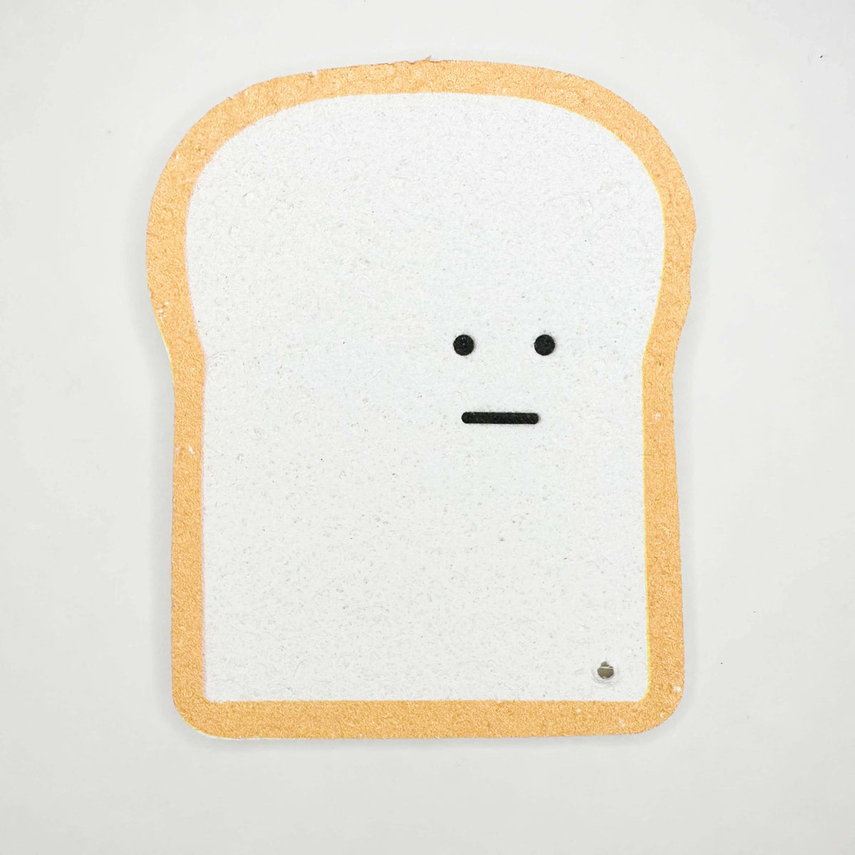 Toy resembling a slice of bread with a face on a white background