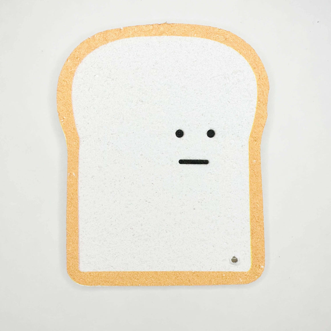 Toy resembling a slice of bread with a face on a white background
