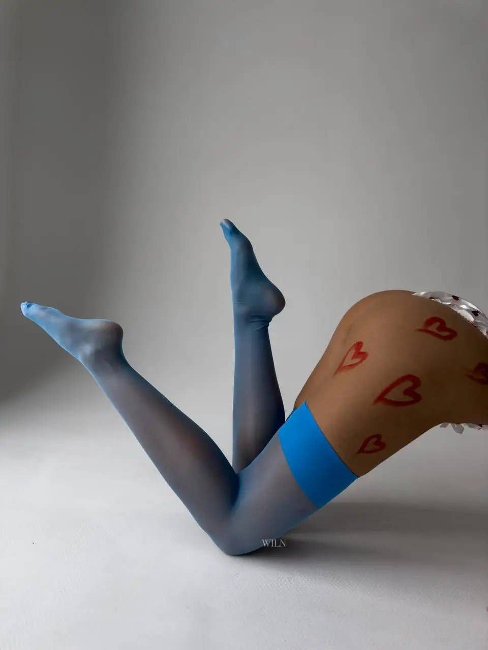 GLAM Stockings Blue displayed on legs, showcasing a smooth finish and stylish blue detail with heart designs.