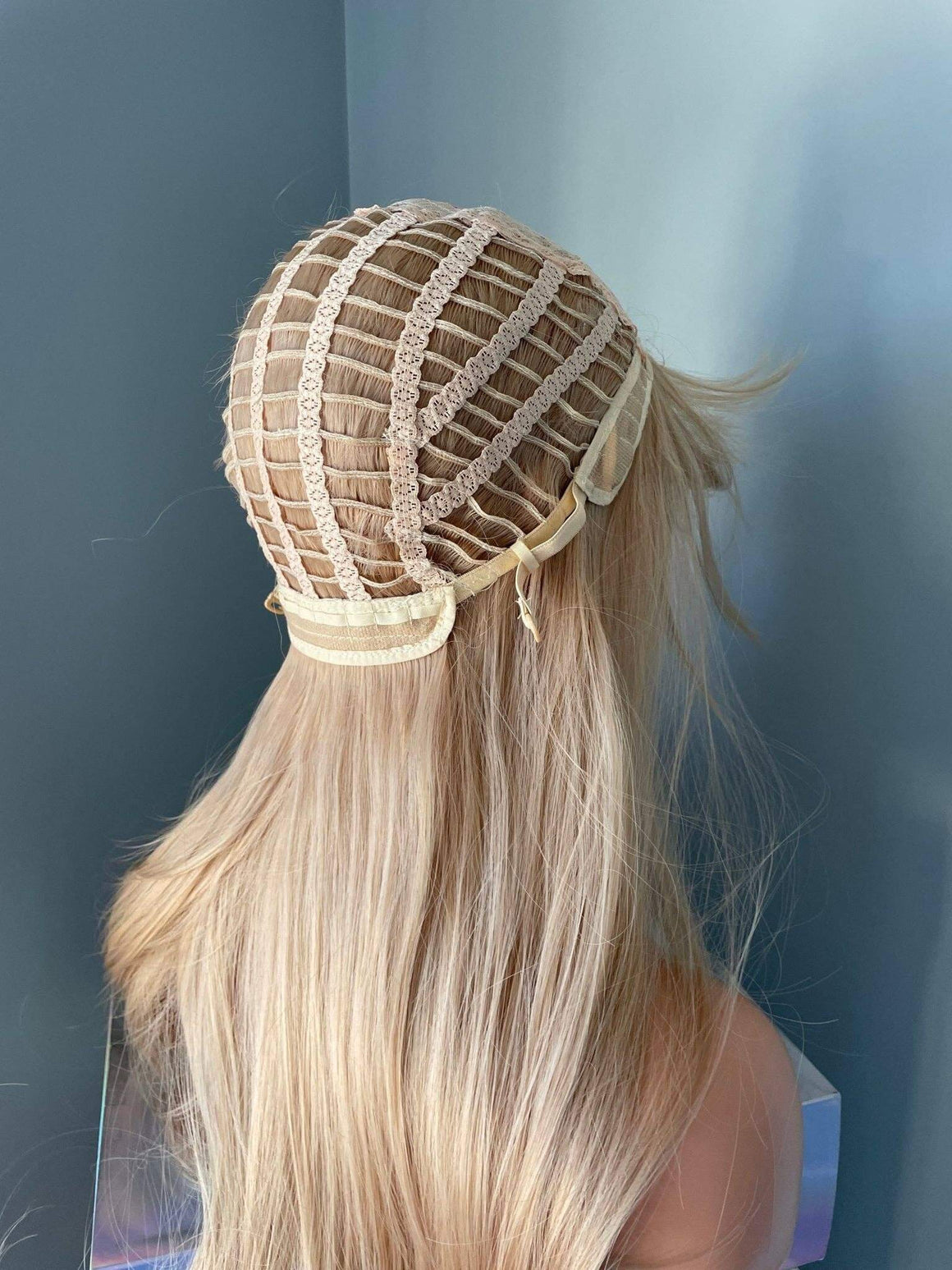 Blonde hair extension with lace front on a plain background